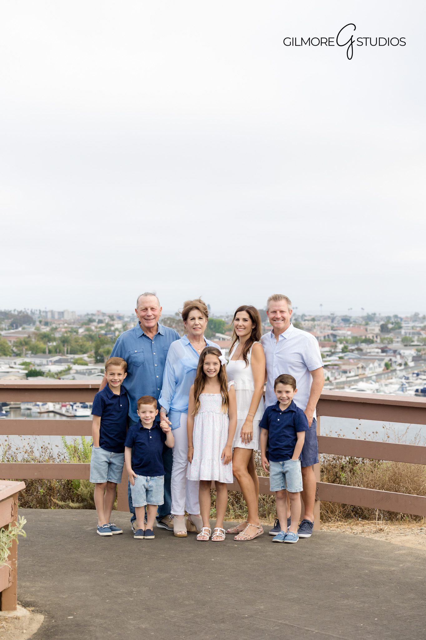 Portrait photographer capturing parents lifting toddler at The Castaways.

Newport Beach family photography showing coastal hillside backdrop.