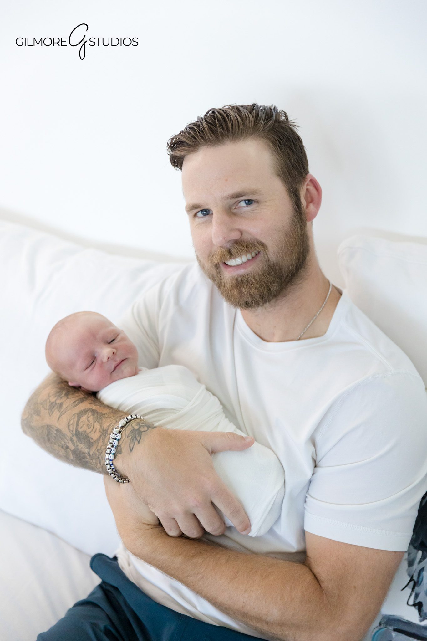 lifestyle photographer capturing quiet newborn moments on master bed,

newborn portrait photography of baby cuddled between parents,