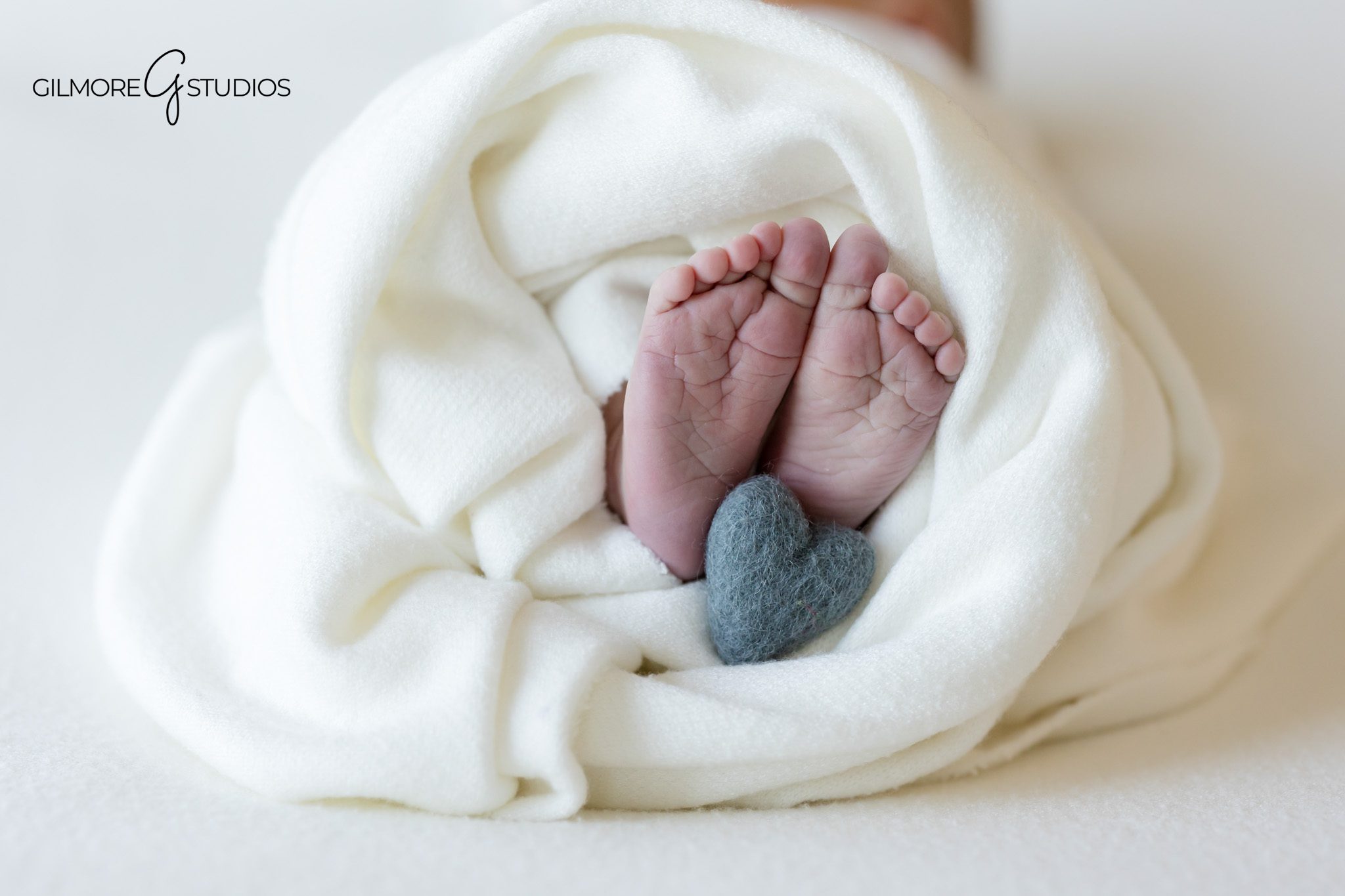 newborn portrait photographer capturing baby wrapped in soft knit swaddle,

baby lifestyle photography showing family laughing during session,