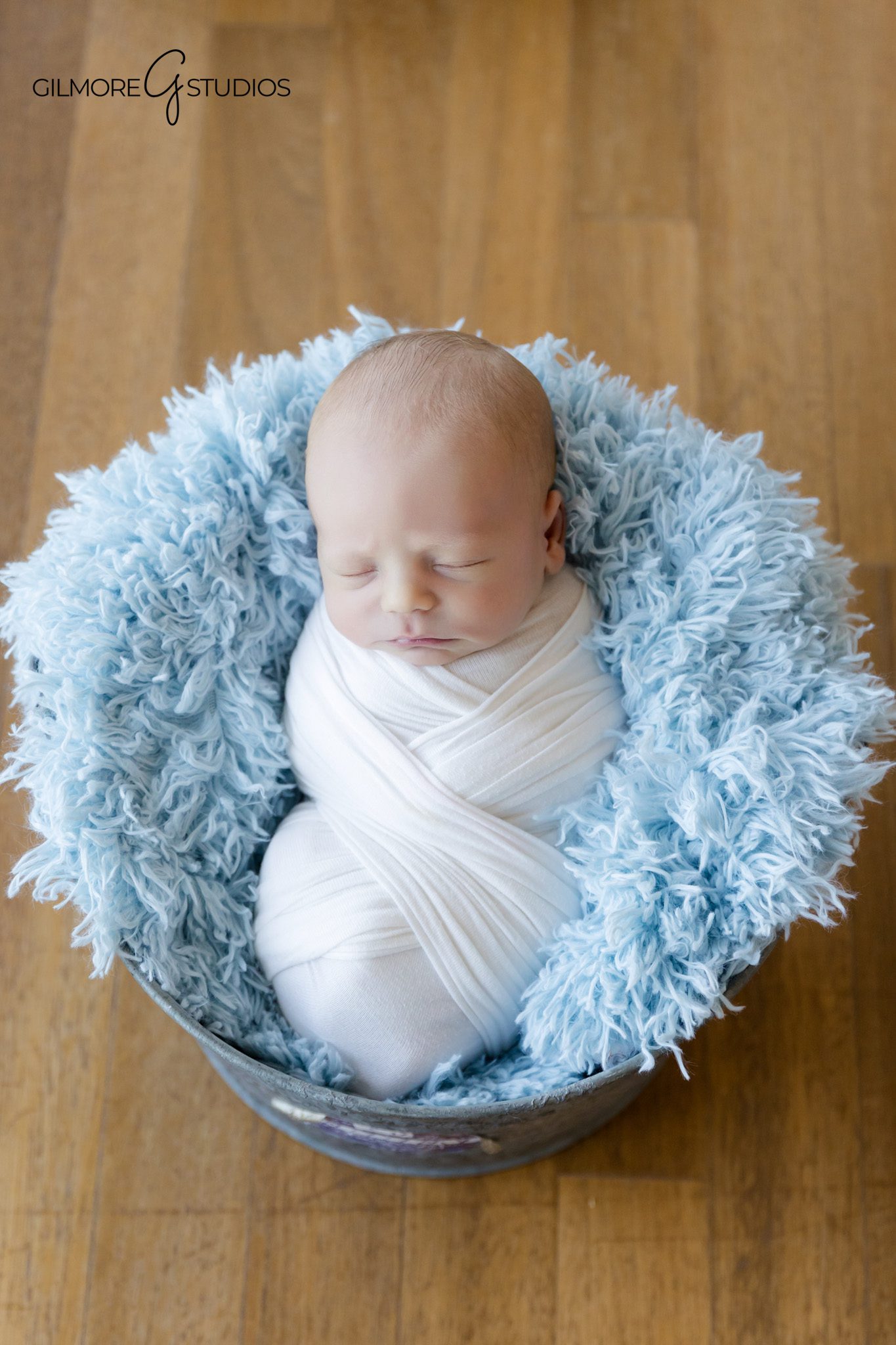 lifestyle photography of baby girl wrapped in neutral colors in san diego,

natural newborn portrait photography featuring parents cuddling baby,