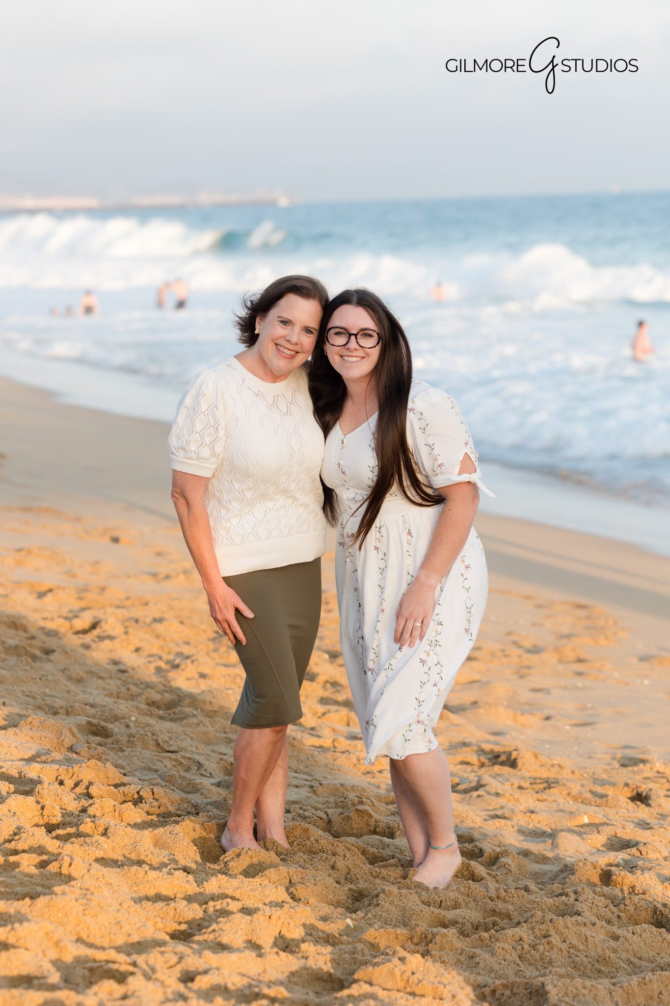 Family photography with warm golden light reflecting off the water.

Portrait photographer capturing family sitting together under the pier structure.