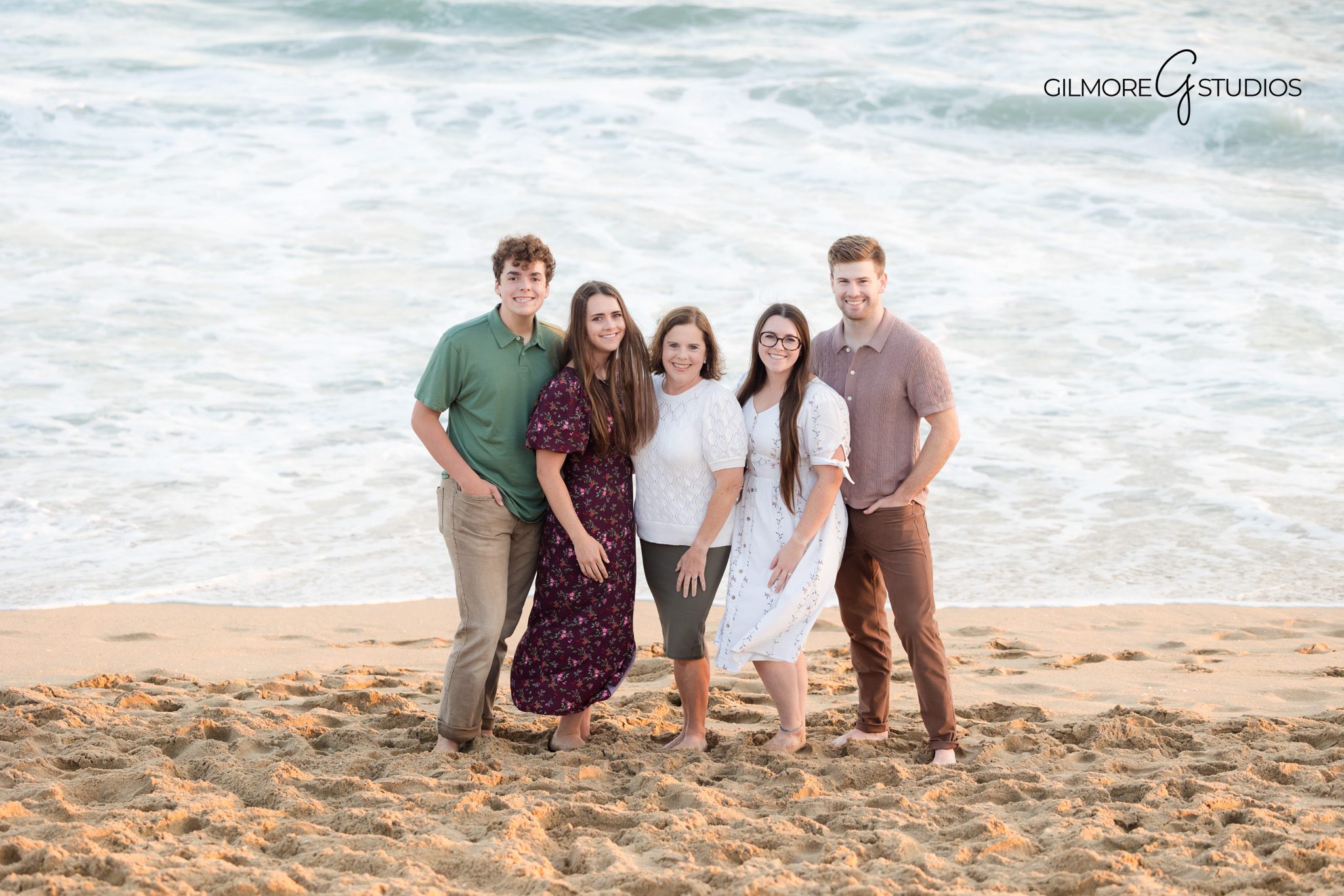 Family portraits photographed under Newport Beach Pier with soft shadows.

Photographer capturing family walking through shallow waves near the pier.