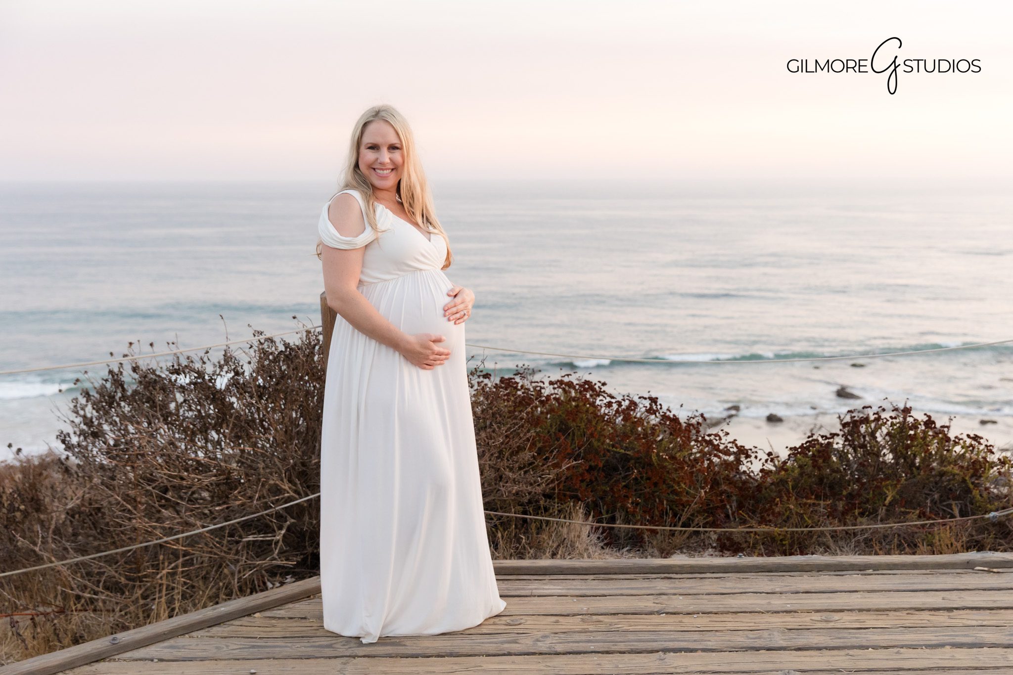 Crystal Cove maternity photography with pastel sunset reflections,

Maternity photographer capturing mother standing along shoreline path,