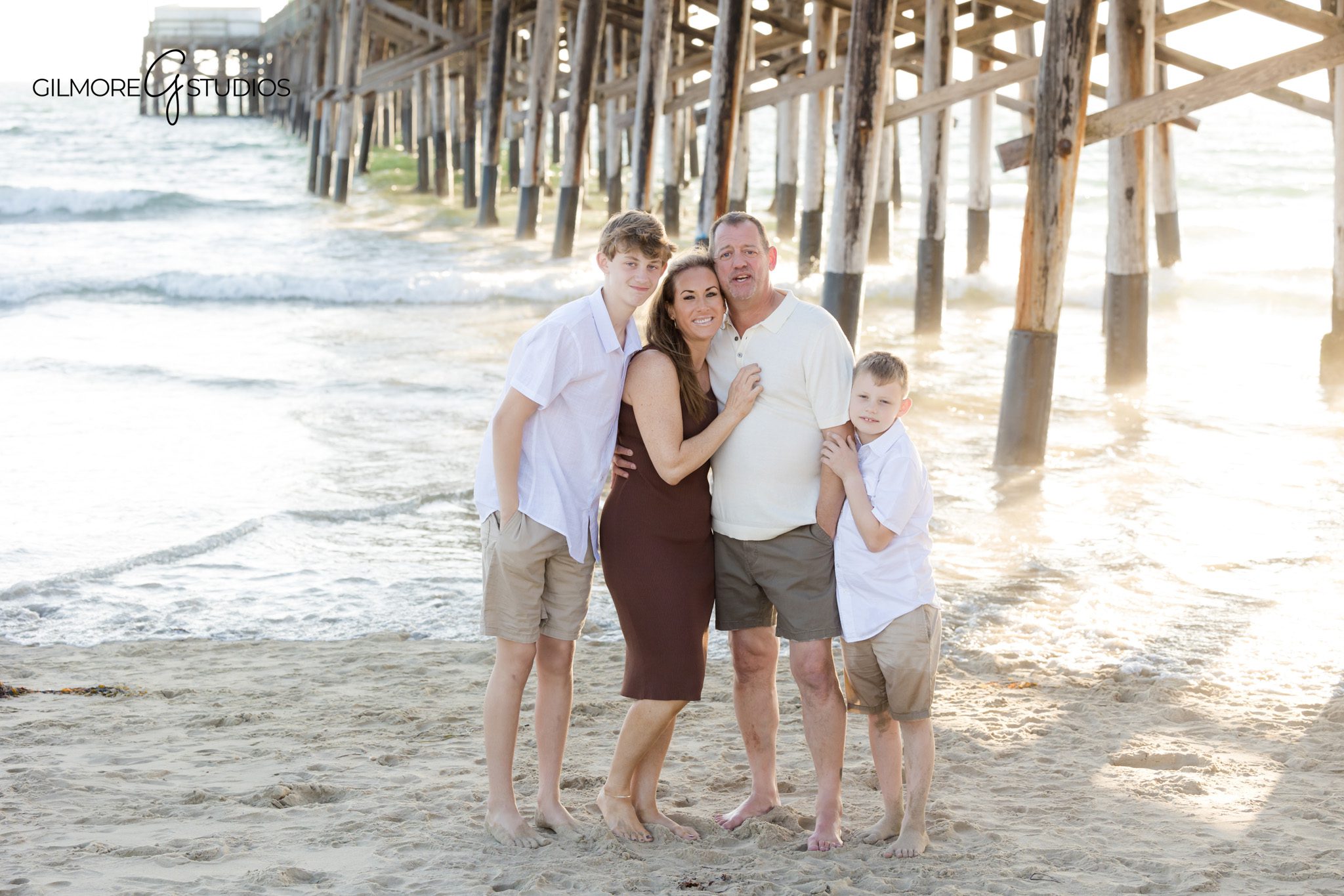Family photography showing parents and adult children at Newport Beach Pier.

Sunset beach photography featuring extended family in warm coastal tones.