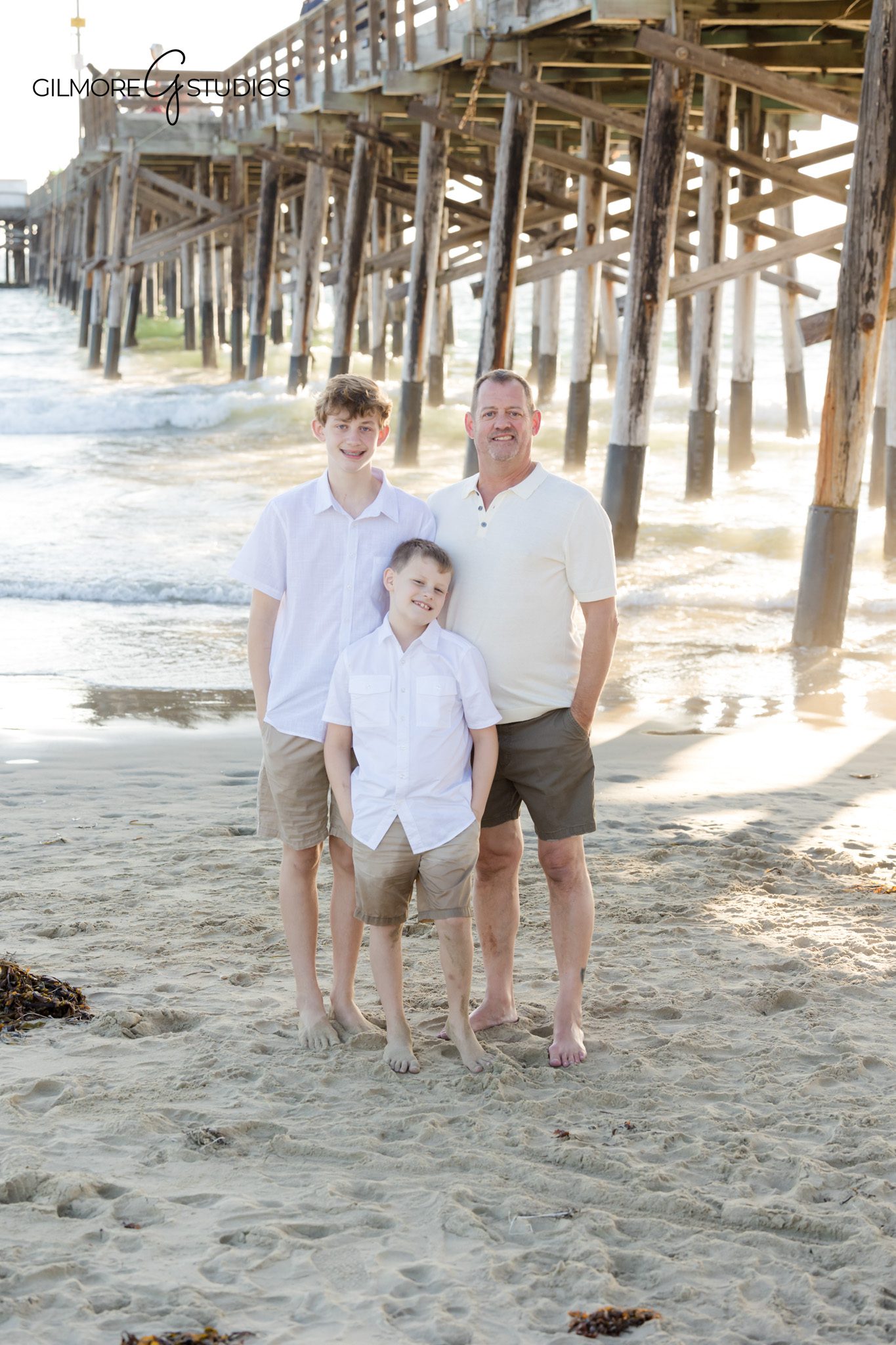OC photographer capturing lifestyle beach photography for extended family.

Newport Pier family portraits with warm sunset glow behind group.