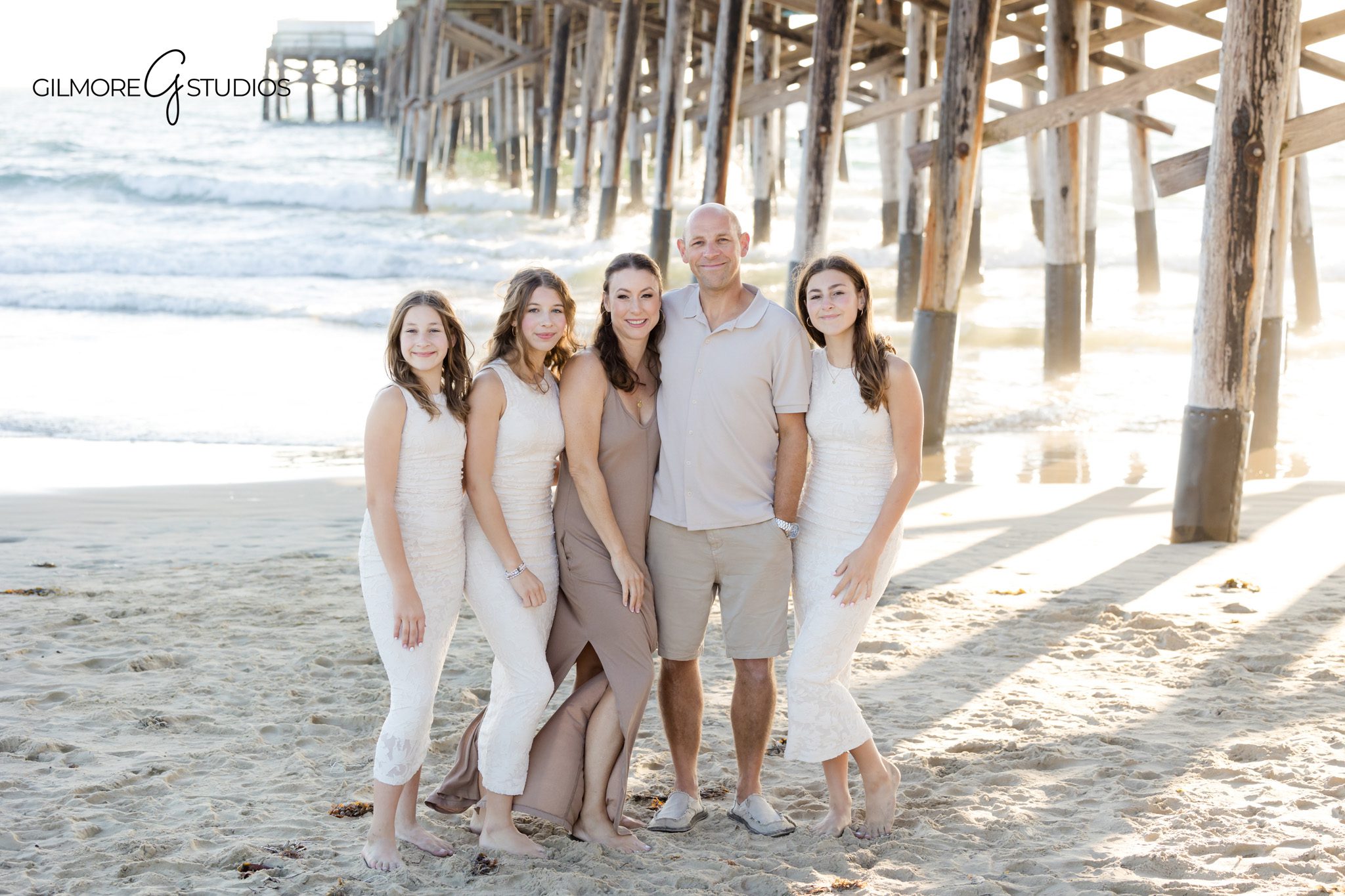 Professional photographer capturing beach hugs during extended family session.

Family portrait photography at Newport Beach Pier with relaxed posing.