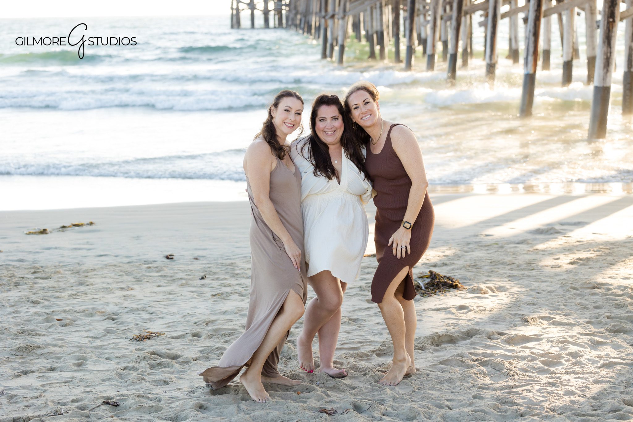 Newport Pier portrait capturing natural smiles and genuine family connection.

Gilmore Studios photographing extended family around coastal rock formations.