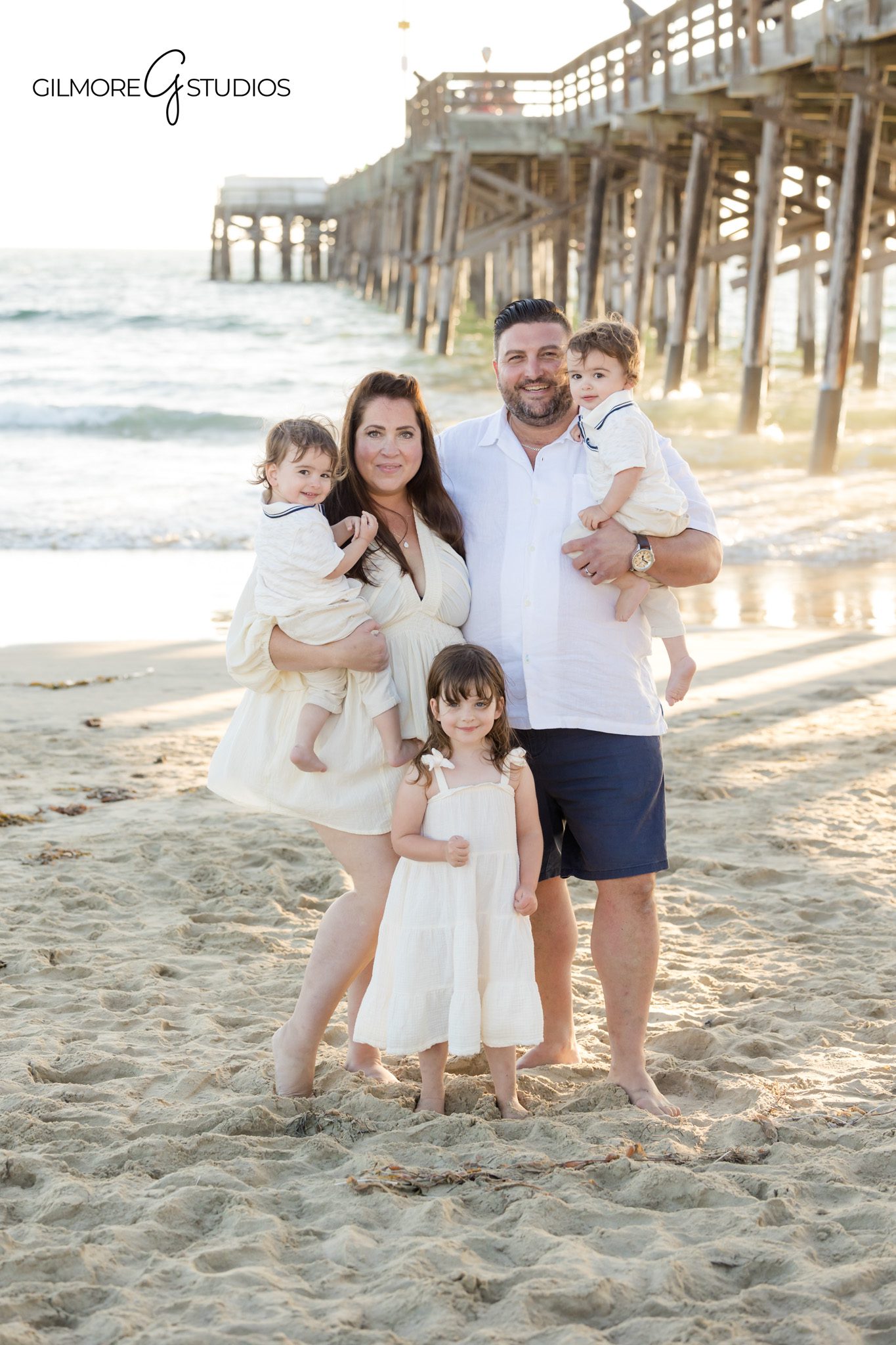 Extended family group photo captured near Newport Pier lifeguard tower.

Orange County photographer capturing cousins posing together on sandy beach.