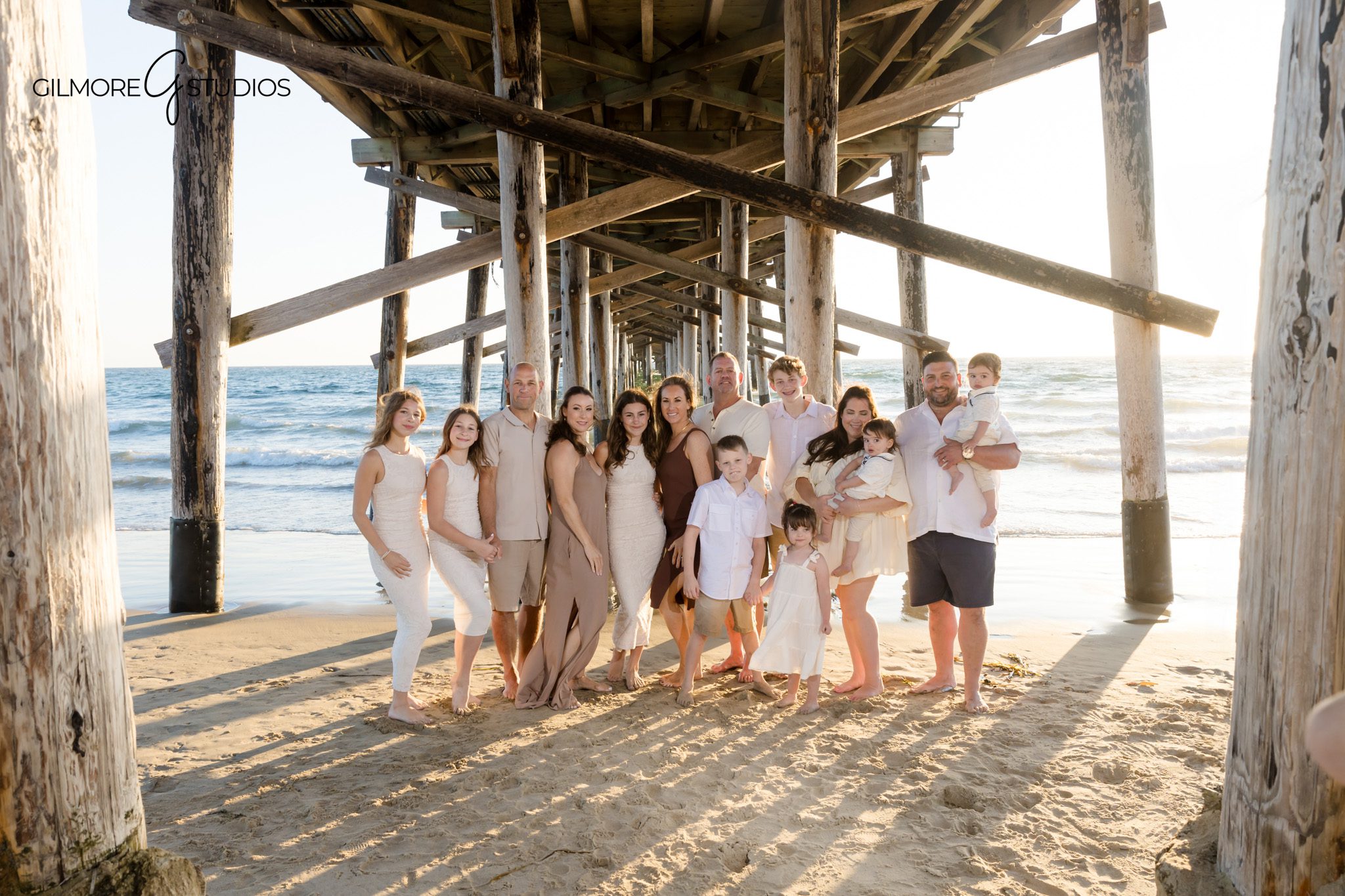 Orange County extended family photographer capturing relaxed beach portraits.

Newport Beach Pier family photography with coordinated outfits in natural light.
