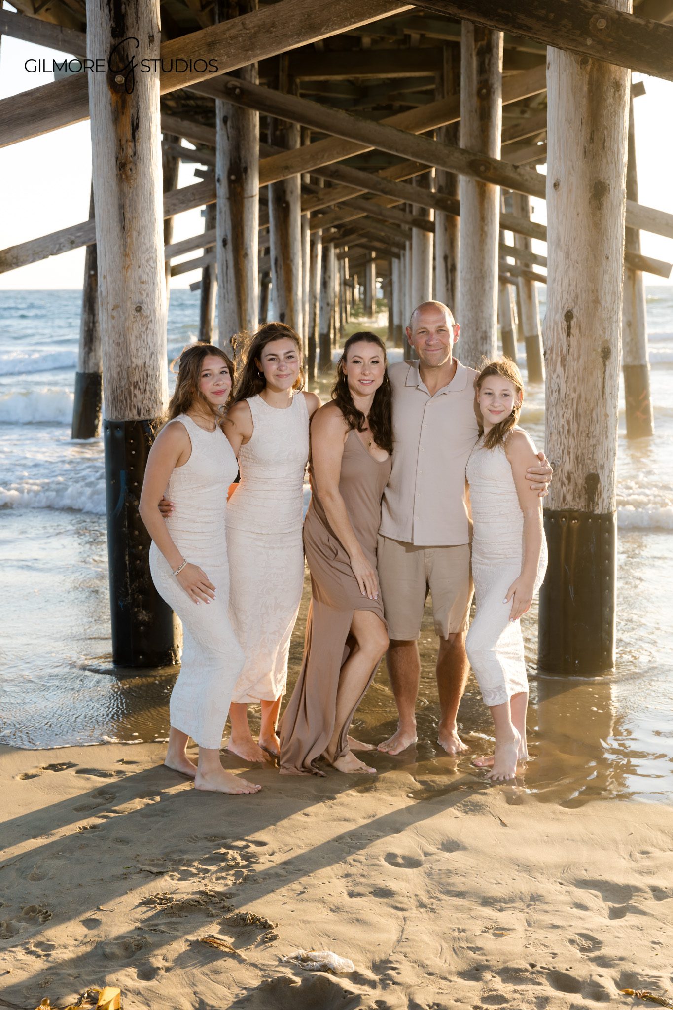 Orange County beach photographer capturing extended family hugging at shoreline.

Family photography showing cousins playing on the sand at Newport Pier.