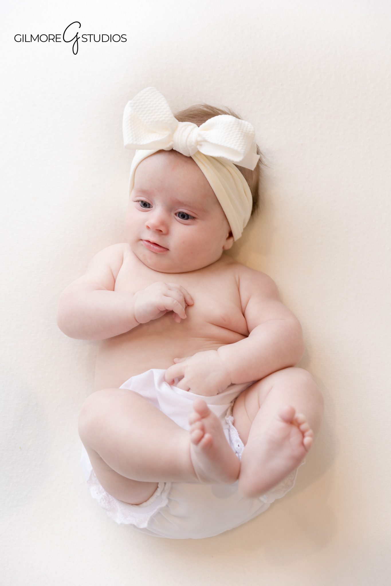 Two month old baby photographed in soft natural light studio.
Photographer capturing peaceful newborn portrait in Orange County.