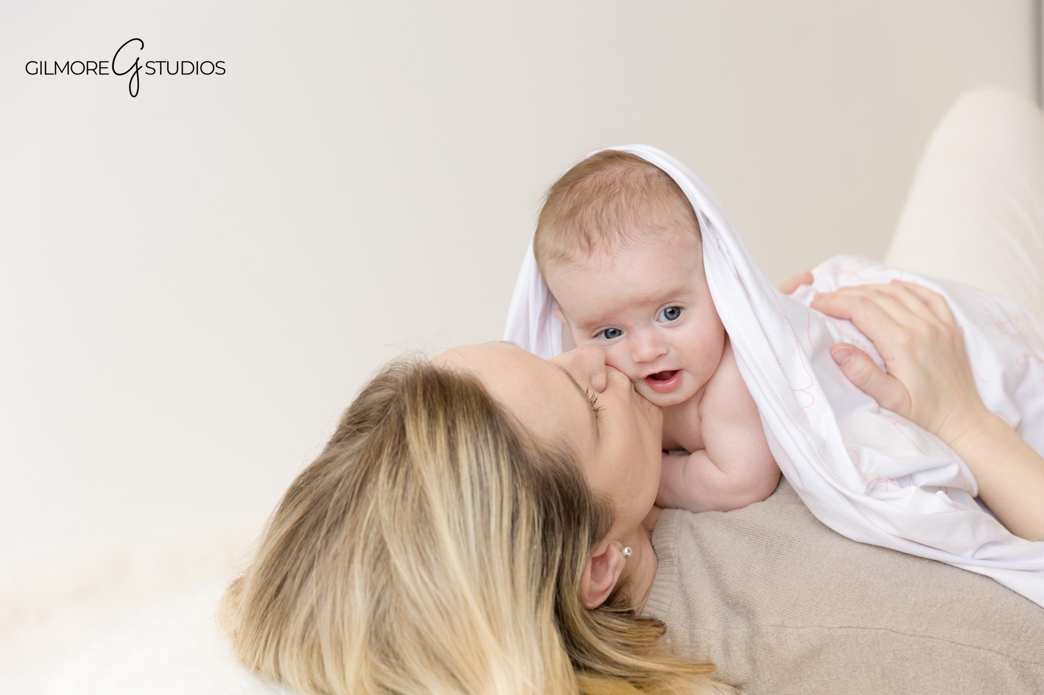 Two month old portrait photography with neutral color palette.
Photographer documenting newborn milestone portraits in OC studio.