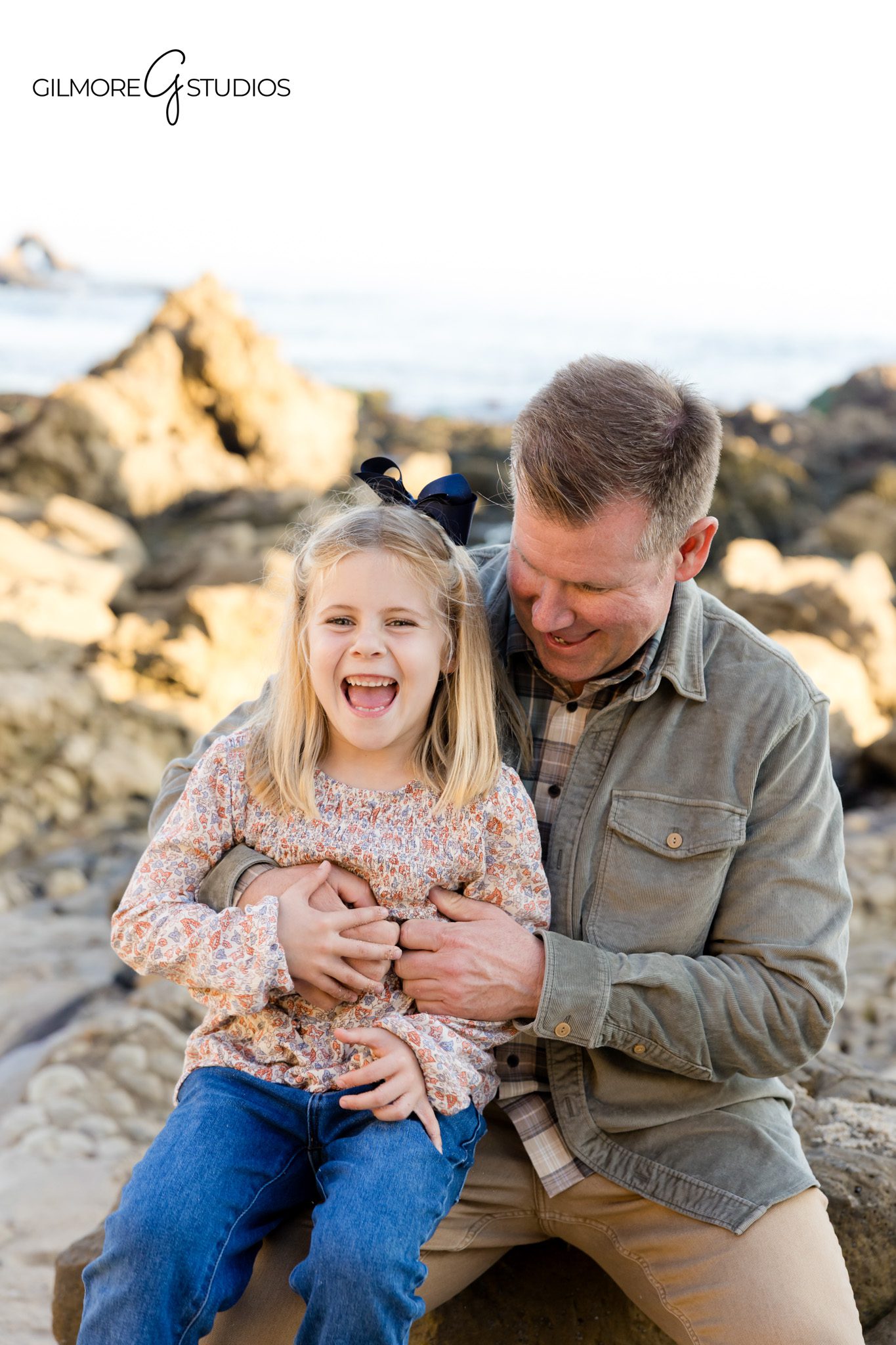 Portrait photographer documenting sunset family session on California beach.

CdM beach photographer capturing parents lifting toddler during warm sunset.