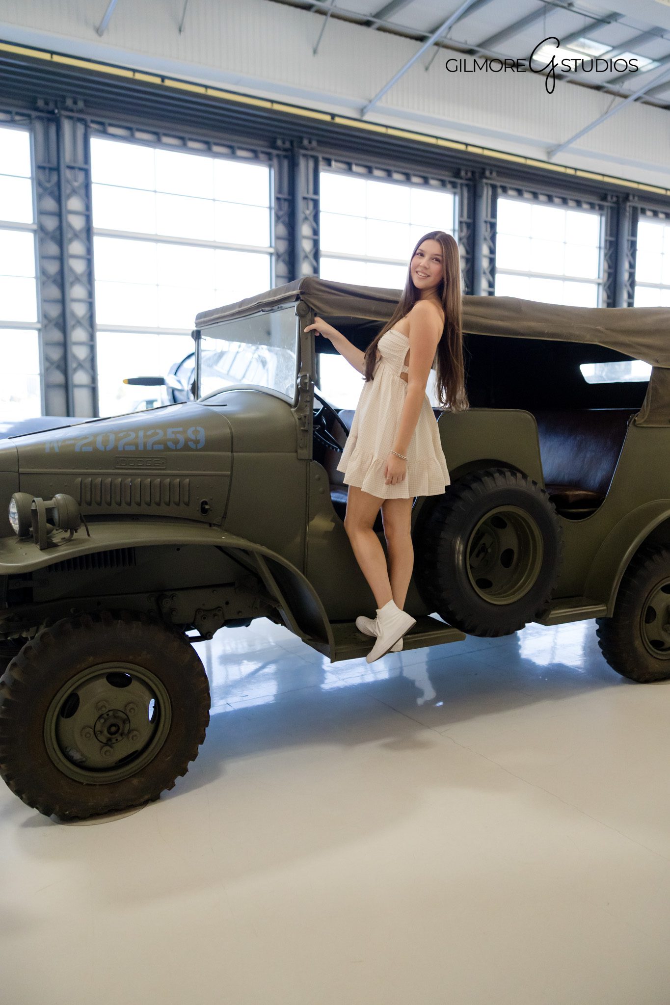 Lyons Air Museum senior girl photography in bright indoor light
Senior girl leaning against airplane wing for modern portrait