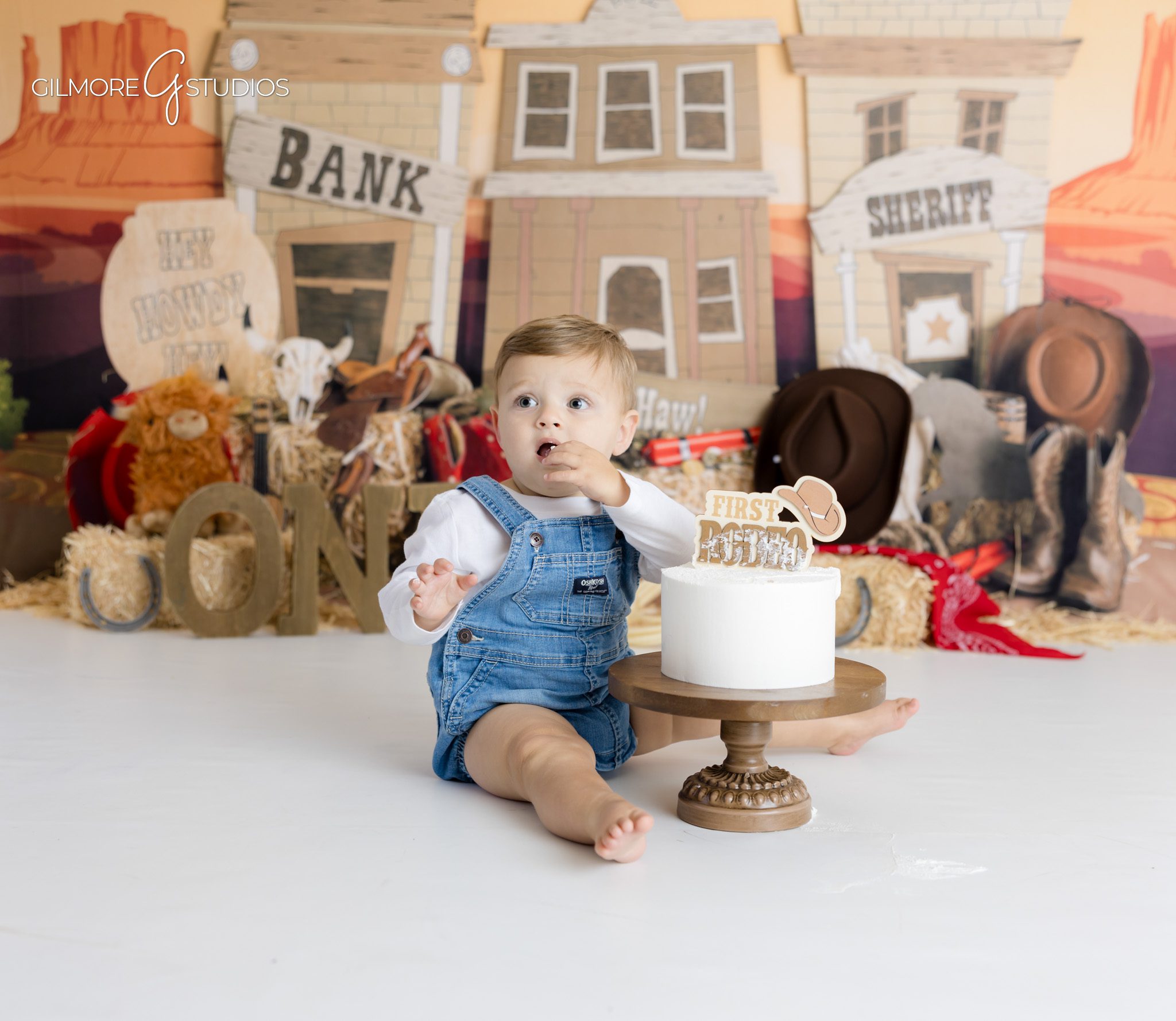 Baby cowboy portrait photography with saddle and vintage props,

Rustic first birthday photography session with cowboy decorations