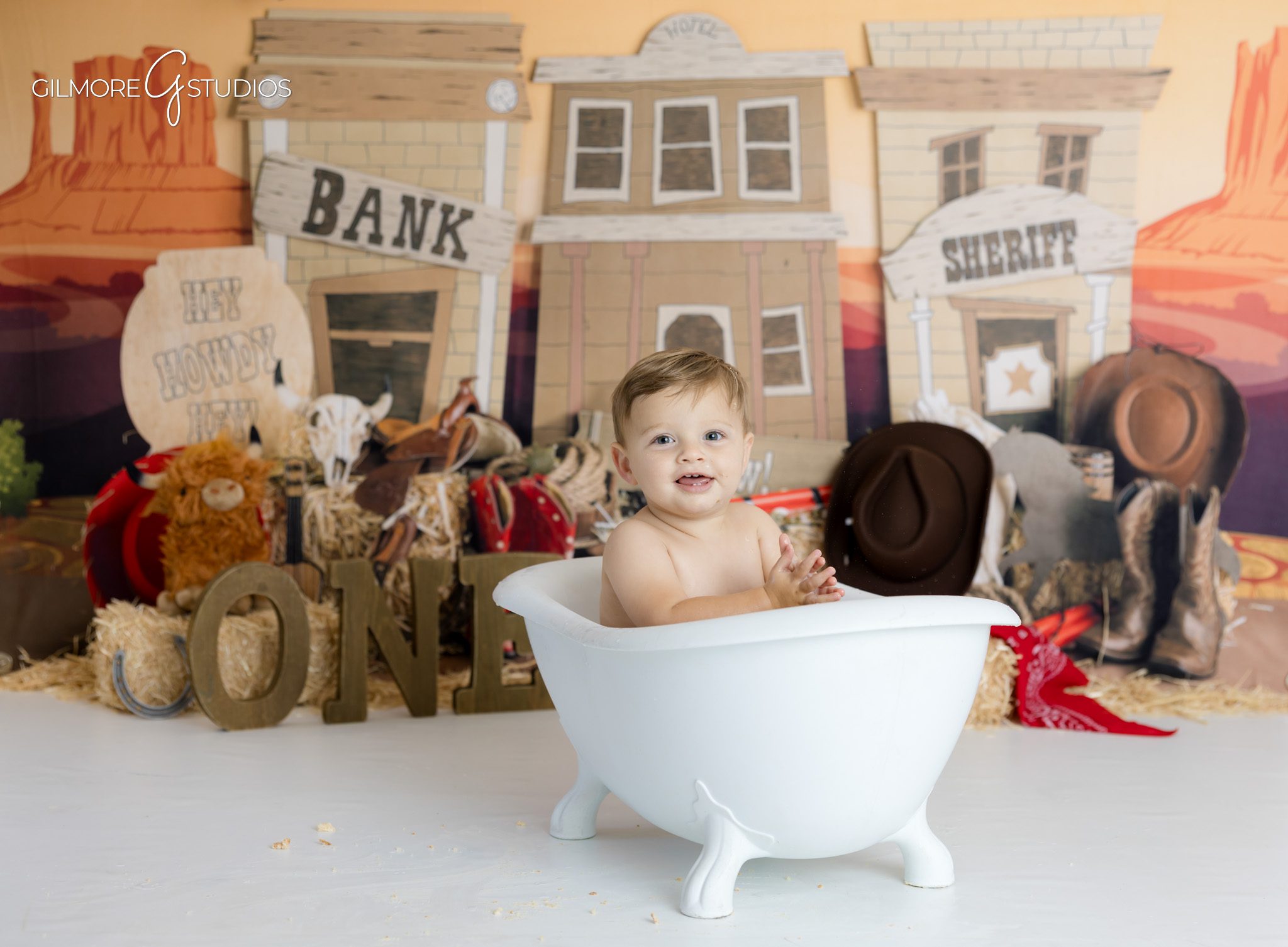 First birthday cowboy cake smash featuring western themed cake,

Baby photography session with cowboy outfit and rope accents
