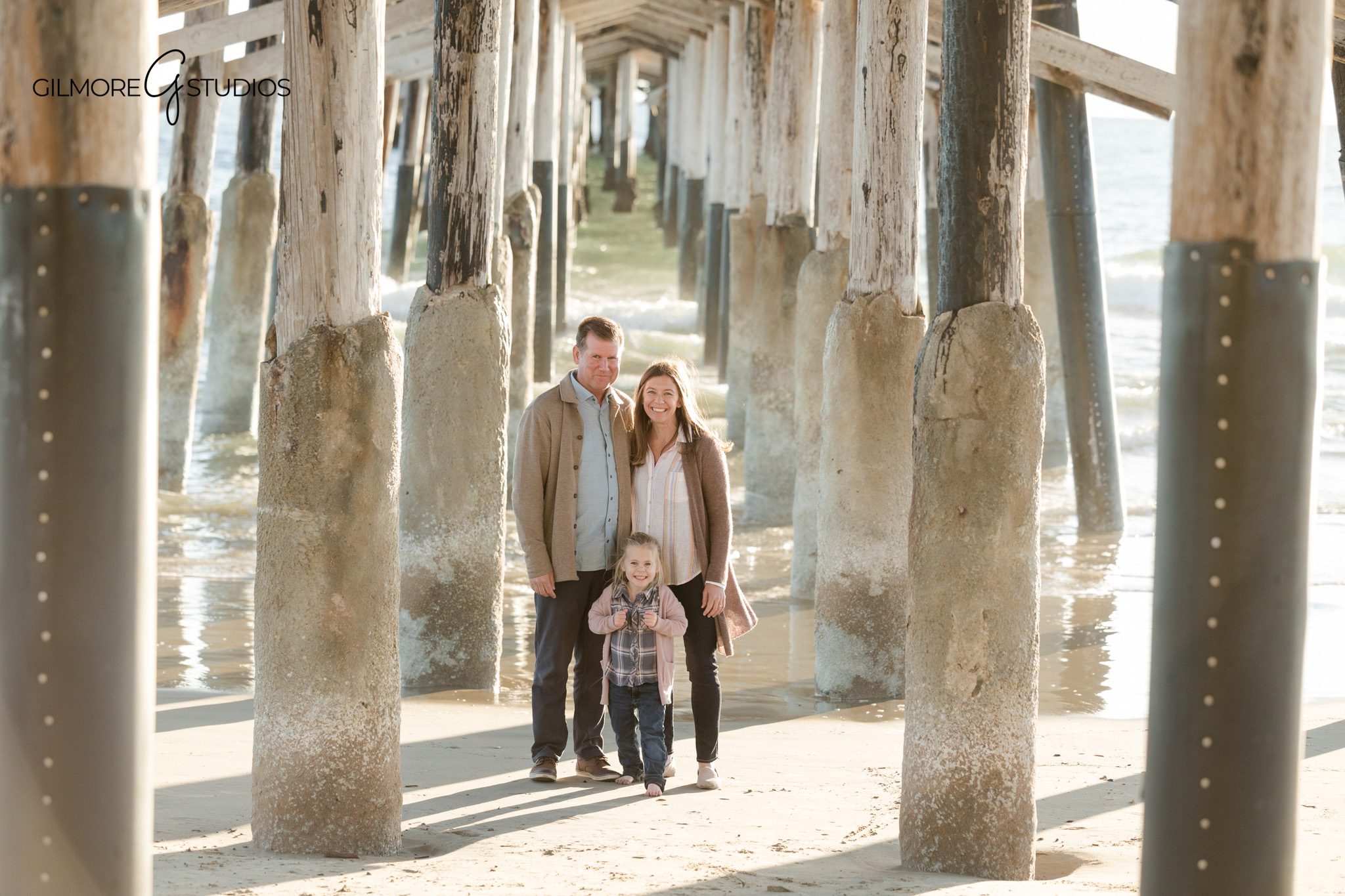 Newport Beach family photographer capturing candid pier moments with a young daughter
Pier family photography session with parents and child at Newport Beach