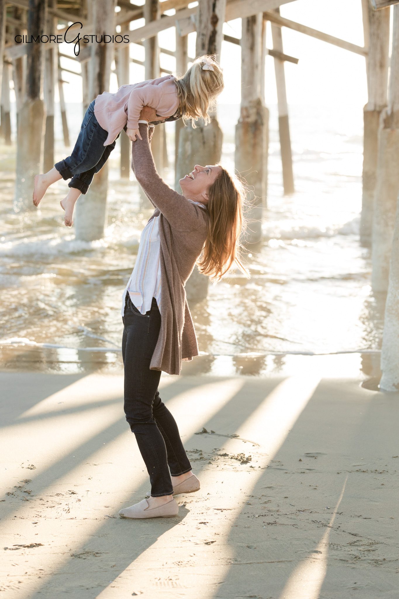 Beach family photography at Newport Pier featuring parents and young daughter
Newport Beach family photographer capturing timeless pier family portraits