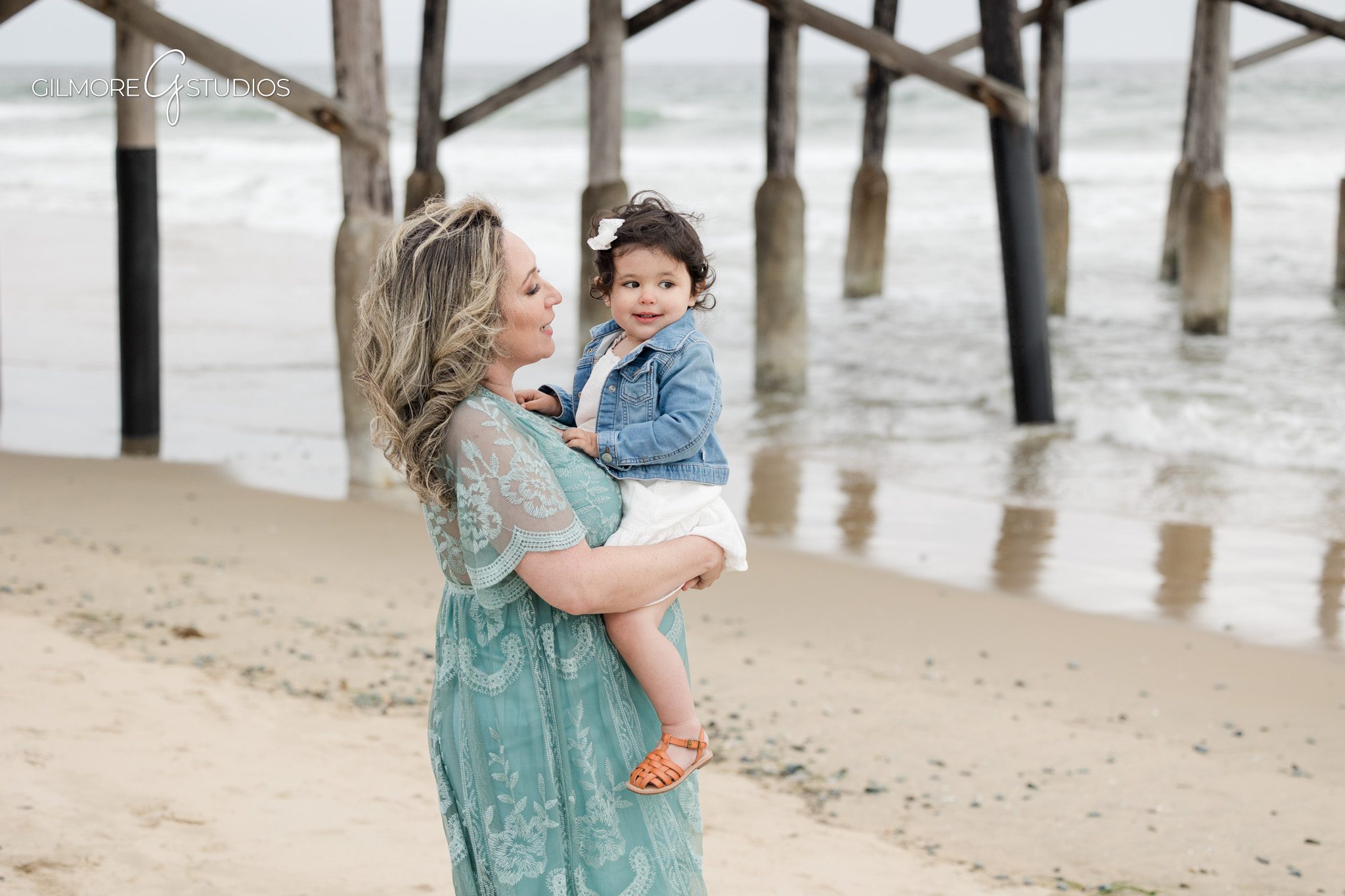 Beach maternity photography session featuring natural connection and movement
Newport Pier maternity portrait photography with serene beach backdrop