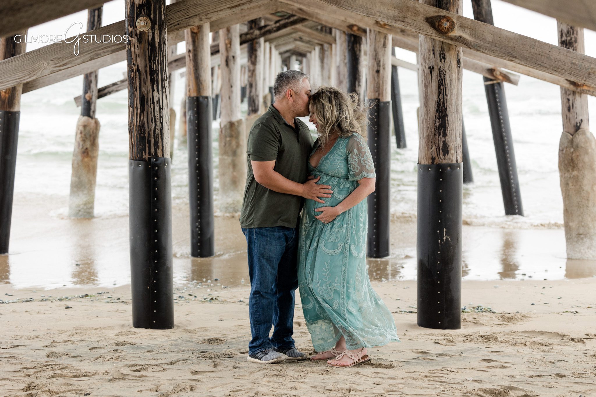 Pregnancy photography at Newport Pier captured by Gilmore Studios
Beach maternity photography with flowing dress and ocean breeze