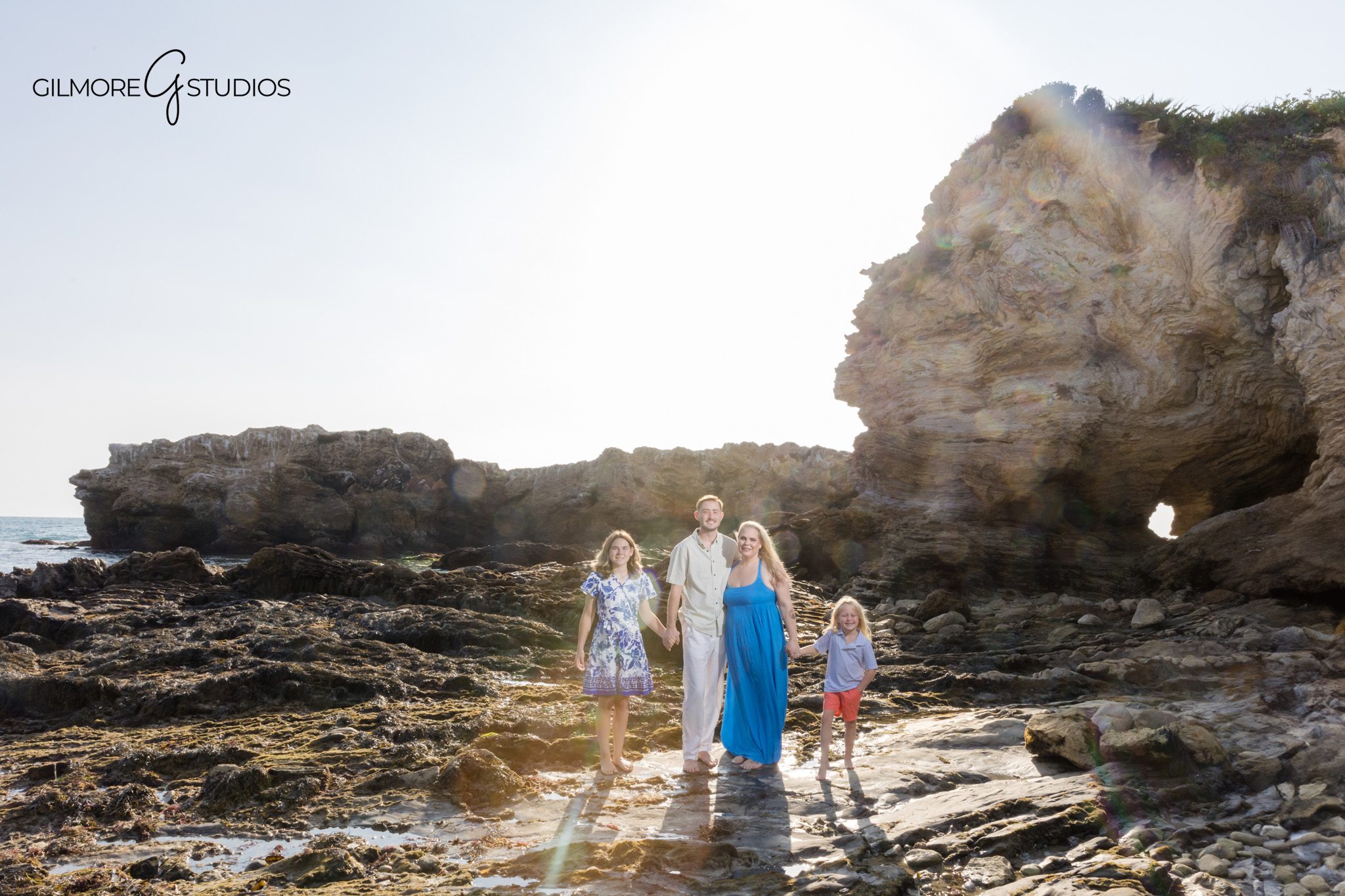 Family portraits photographed near rocky cove at Corona del Mar.

Gilmore Studios photographer capturing engagement session laughter.