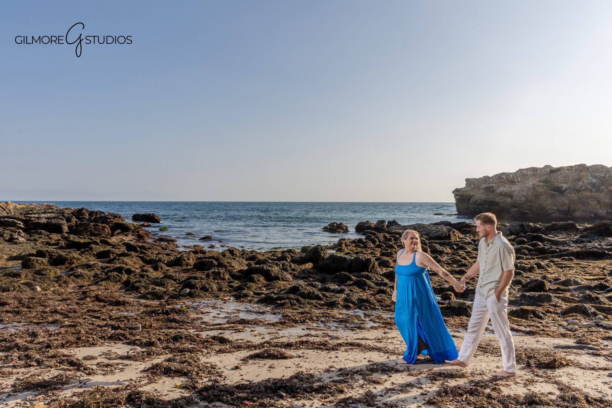 Professional photographer capturing ring close-up on sandy beach.

Family portrait photography showing gentle waves behind them.