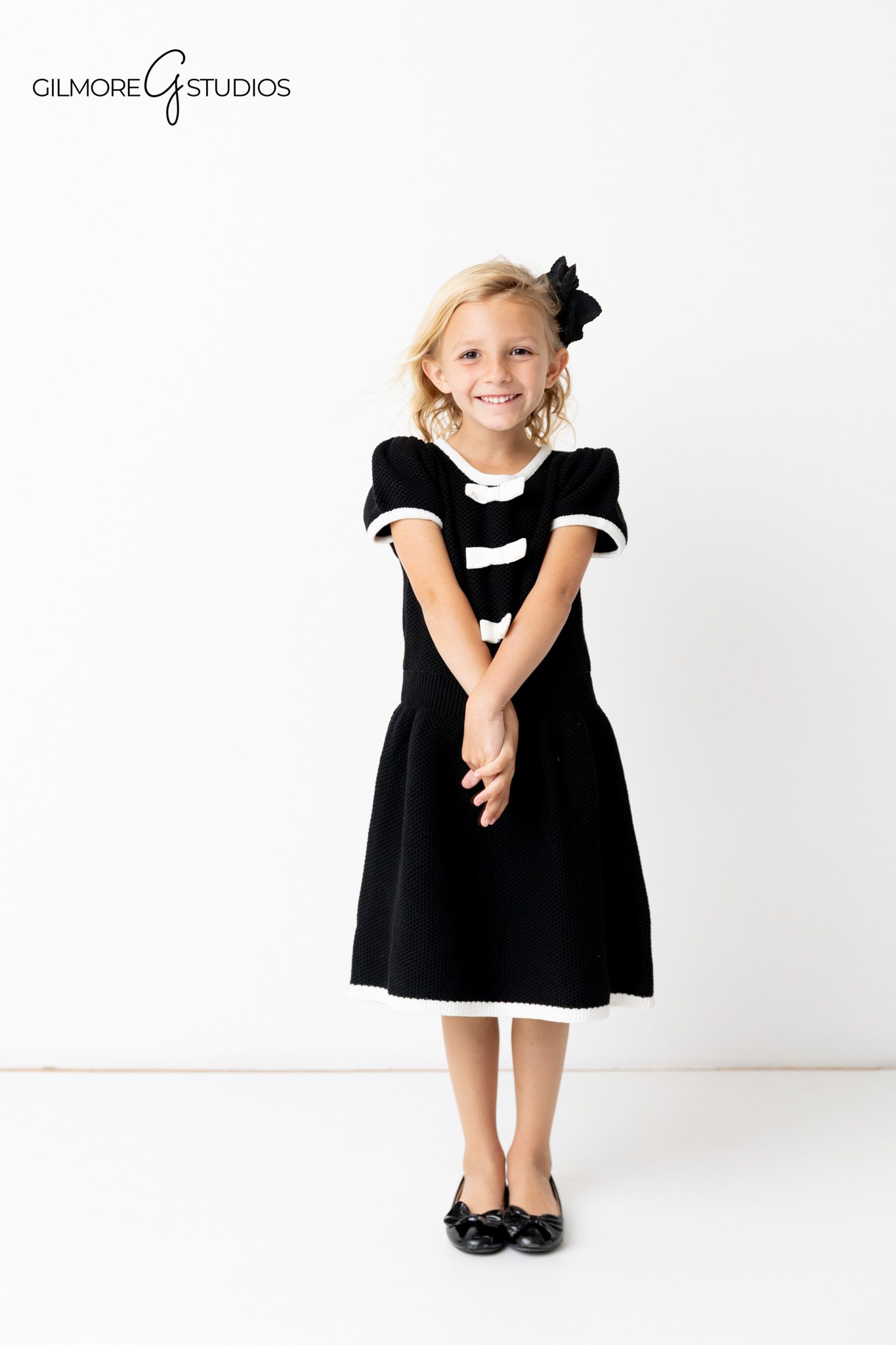 White backdrop portrait photographer capturing elegant family expressions.

Studio portrait photography featuring family dressed in neutral formal tones.