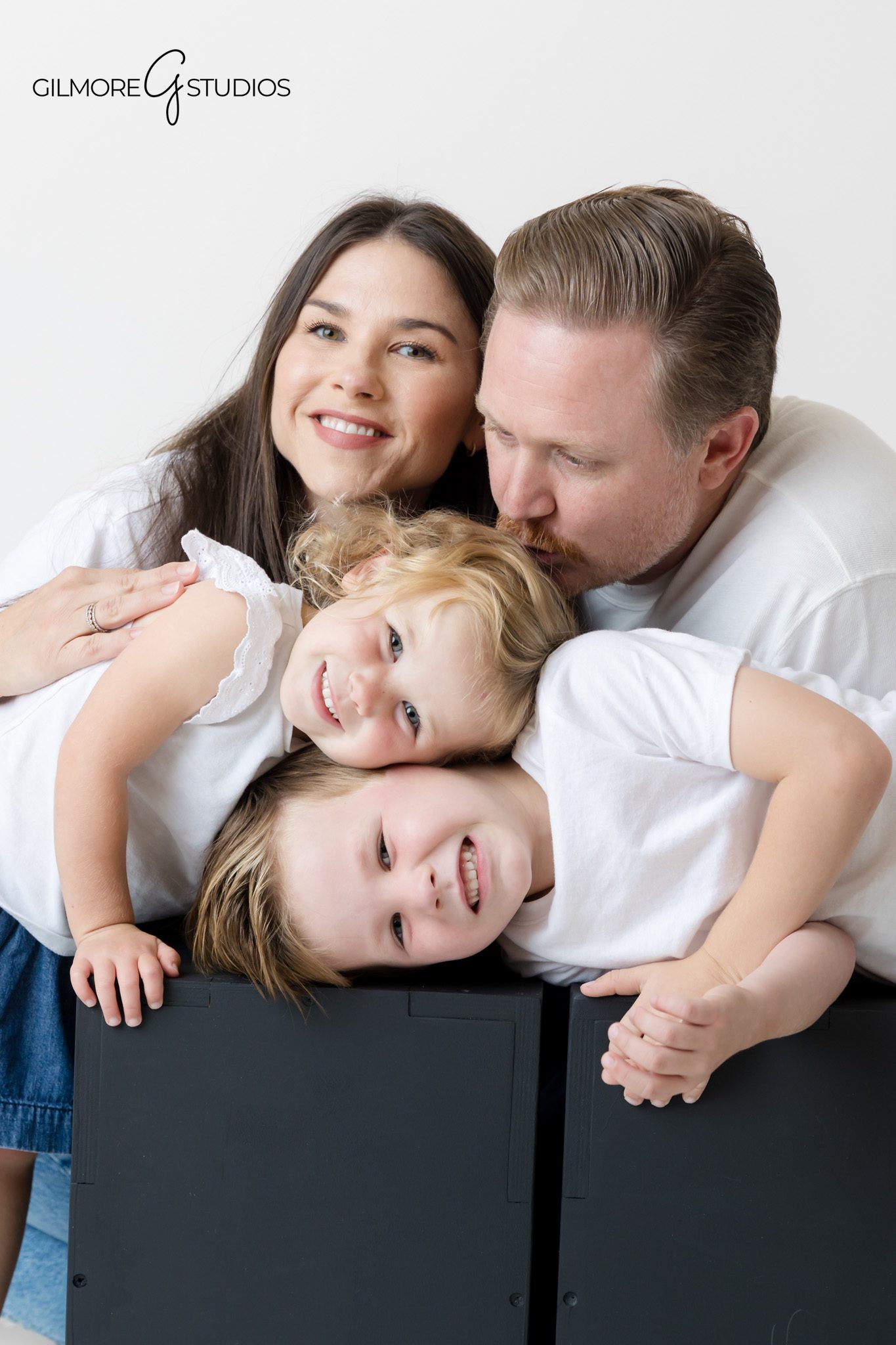 Matching denim outfits highlighted in studio family photography.

Light and airy family portrait session with white shirts and jeans.