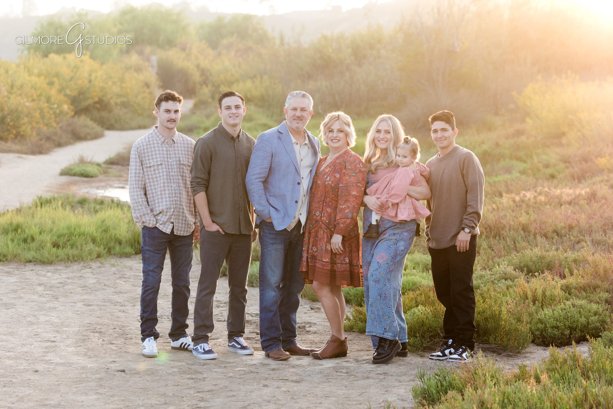 Photographer capturing Back Bay landscape around extended family.

Newport Beach family portrait photography in open field at Back Bay.