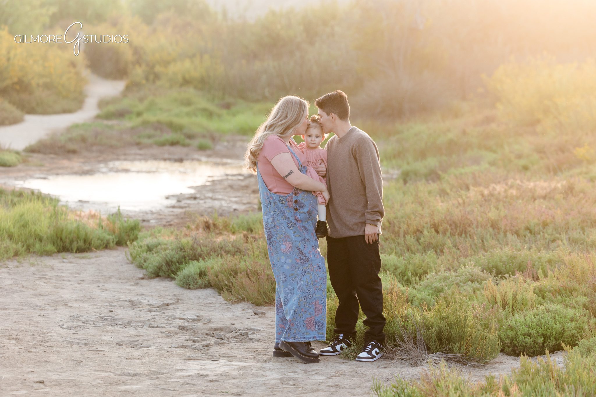 Outdoor family photography with warm pastel lighting at Back Bay.

Photographer capturing Back Bay water and hills behind family.