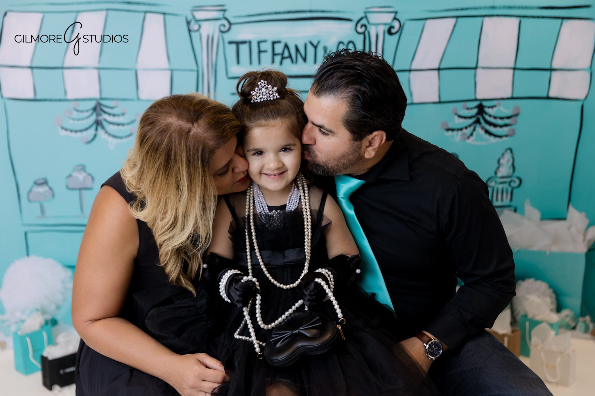 Tiffany blue and white birthday photography with classic bow accents.
Portrait photography of birthday girl sitting by Tiffany gift boxes.