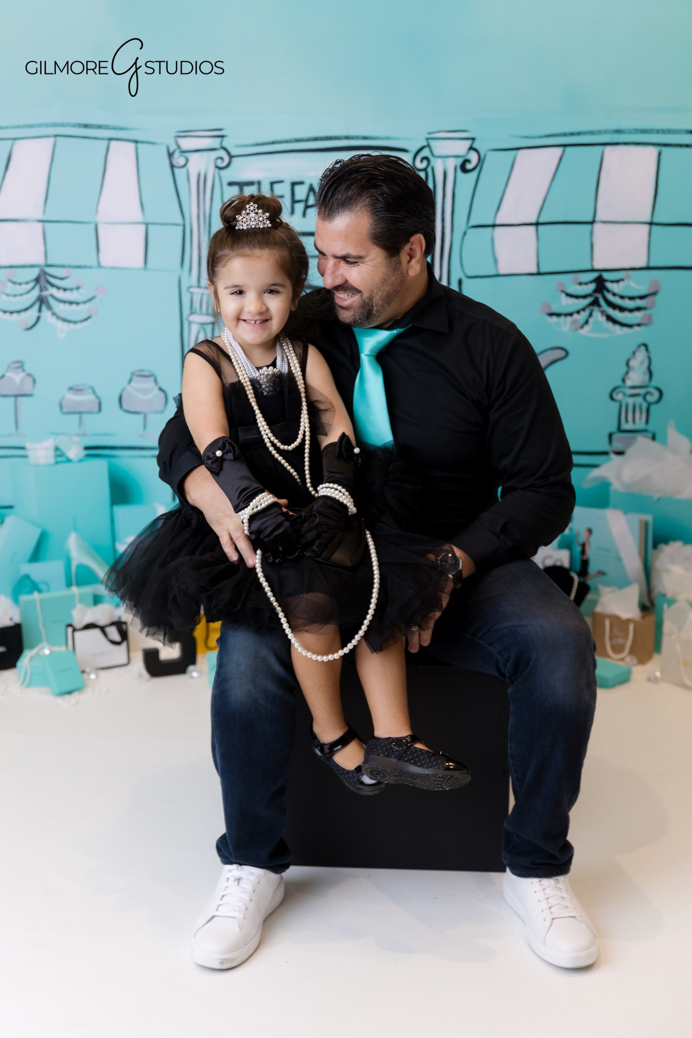 Three year old photographed with Tiffany cake and shiny decorations.
Tiffany birthday portrait photographer capturing soft teal tones.