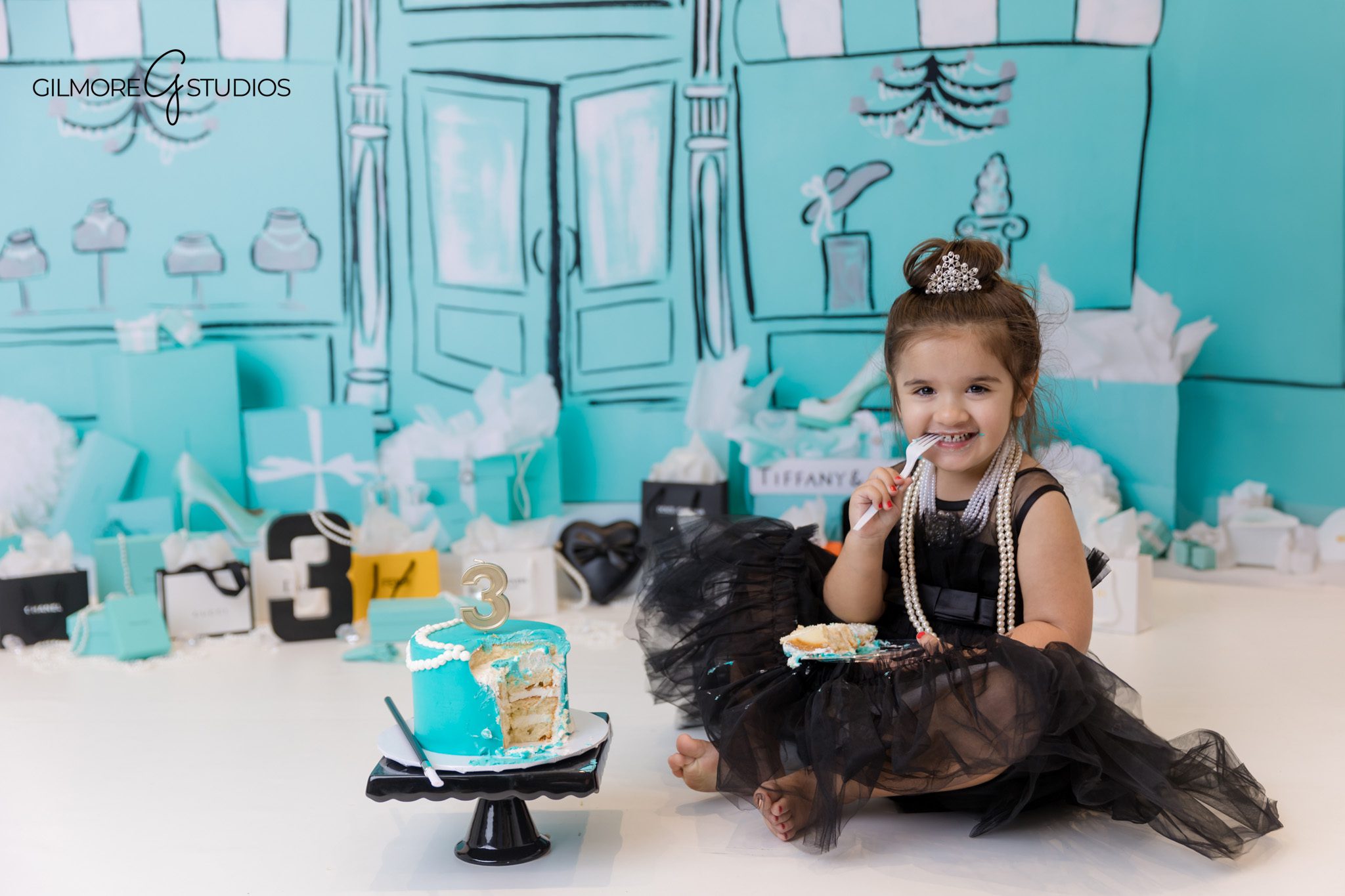 Three year old photographed with Tiffany blue tassels and balloons.
Turquoise birthday session photography for young girl turning three.