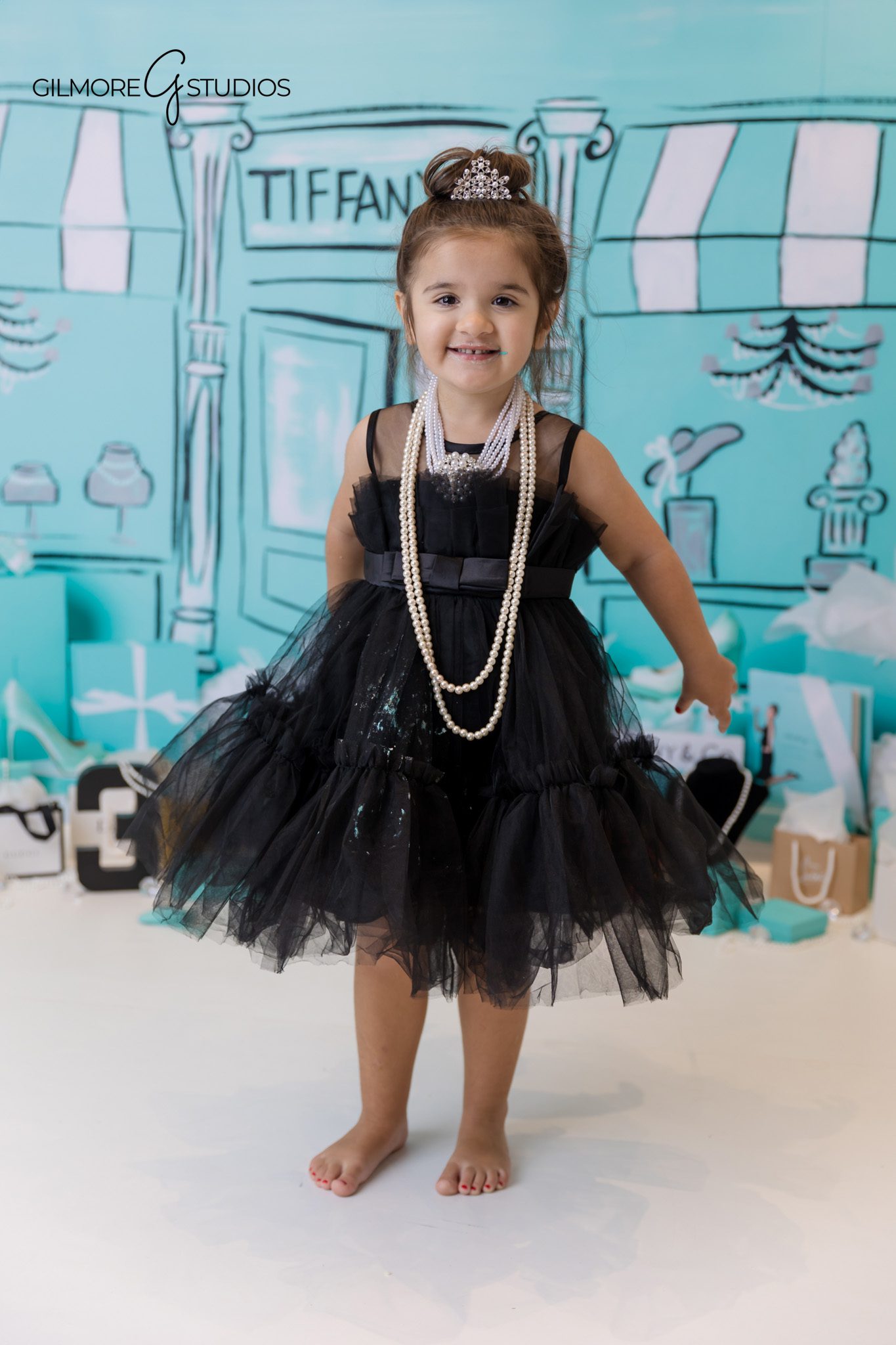 Beautiful Tiffany style photography with girl posing on stool.
Tiffany’s theme portrait of birthday girl holding mini gift box.