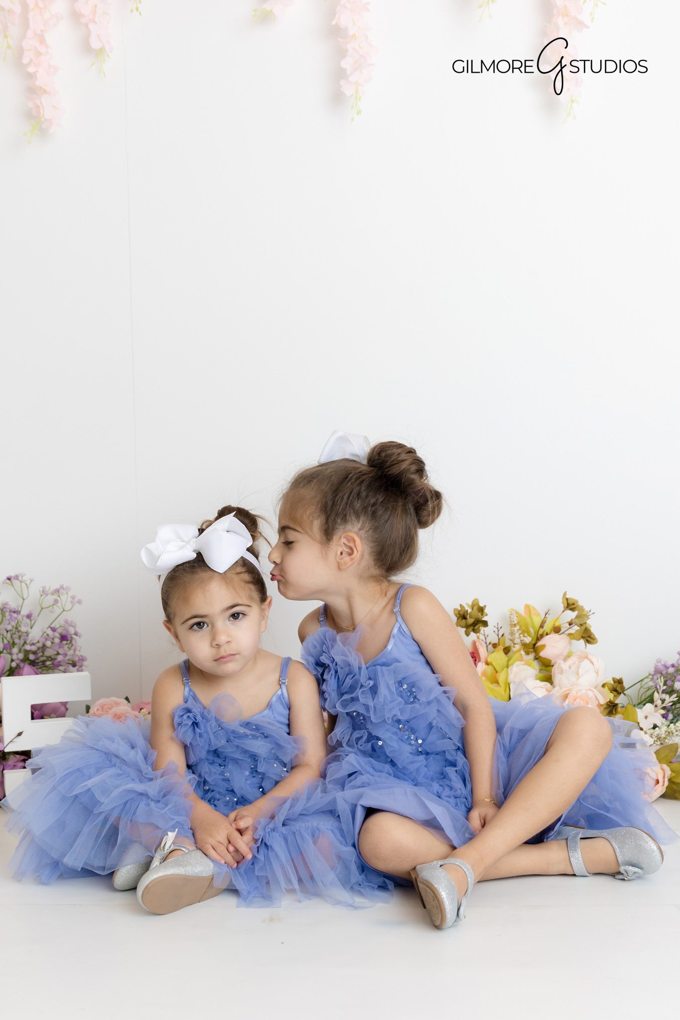 Young siblings playing and hugging on set during a lifestyle birthday photoshoot session in Gilbert AZ