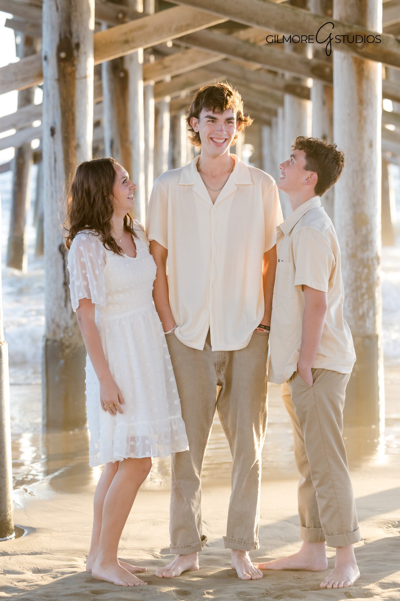 Golden hour family photography with waves behind Newport Beach Pier.
Newport Beach photographer capturing candid family hugs at sunset.
