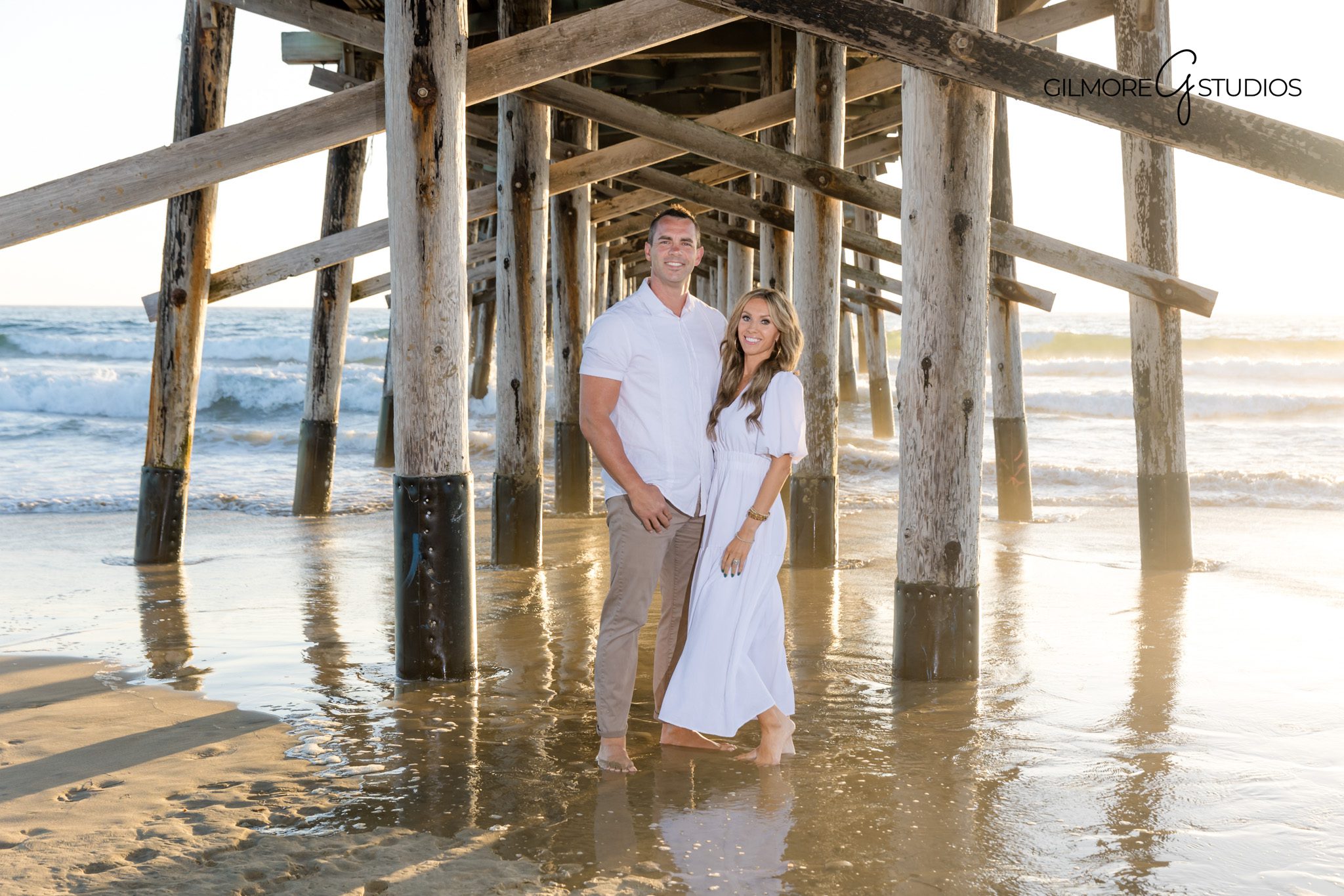 Coastal family portraits taken at sunset on the Newport Beach shoreline.
Lifestyle family photography walking toward Newport Beach Pier.