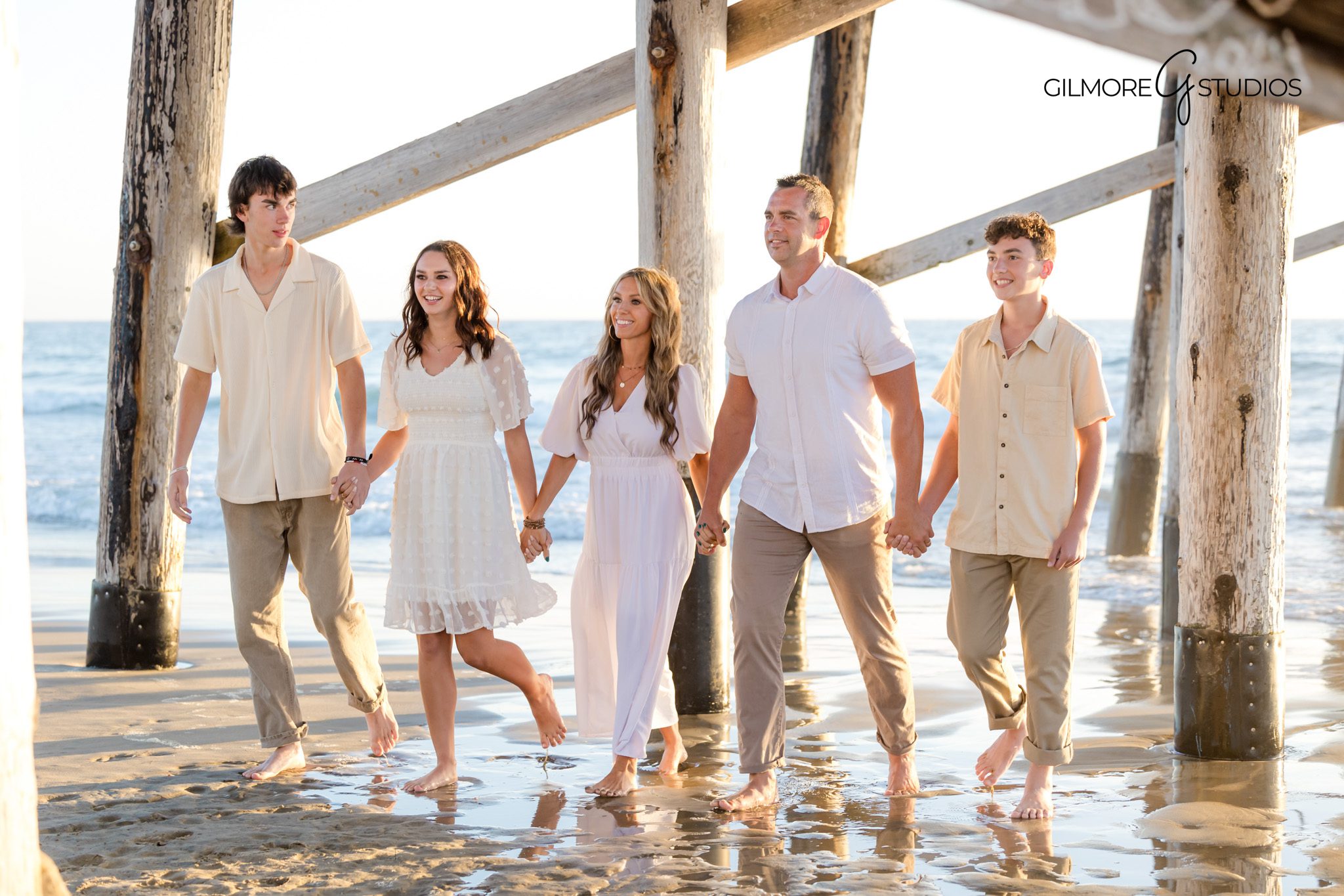 Coastal sunset family portraits with Newport Beach Pier in background.
Orange County photographer capturing sunset family session at the pier.