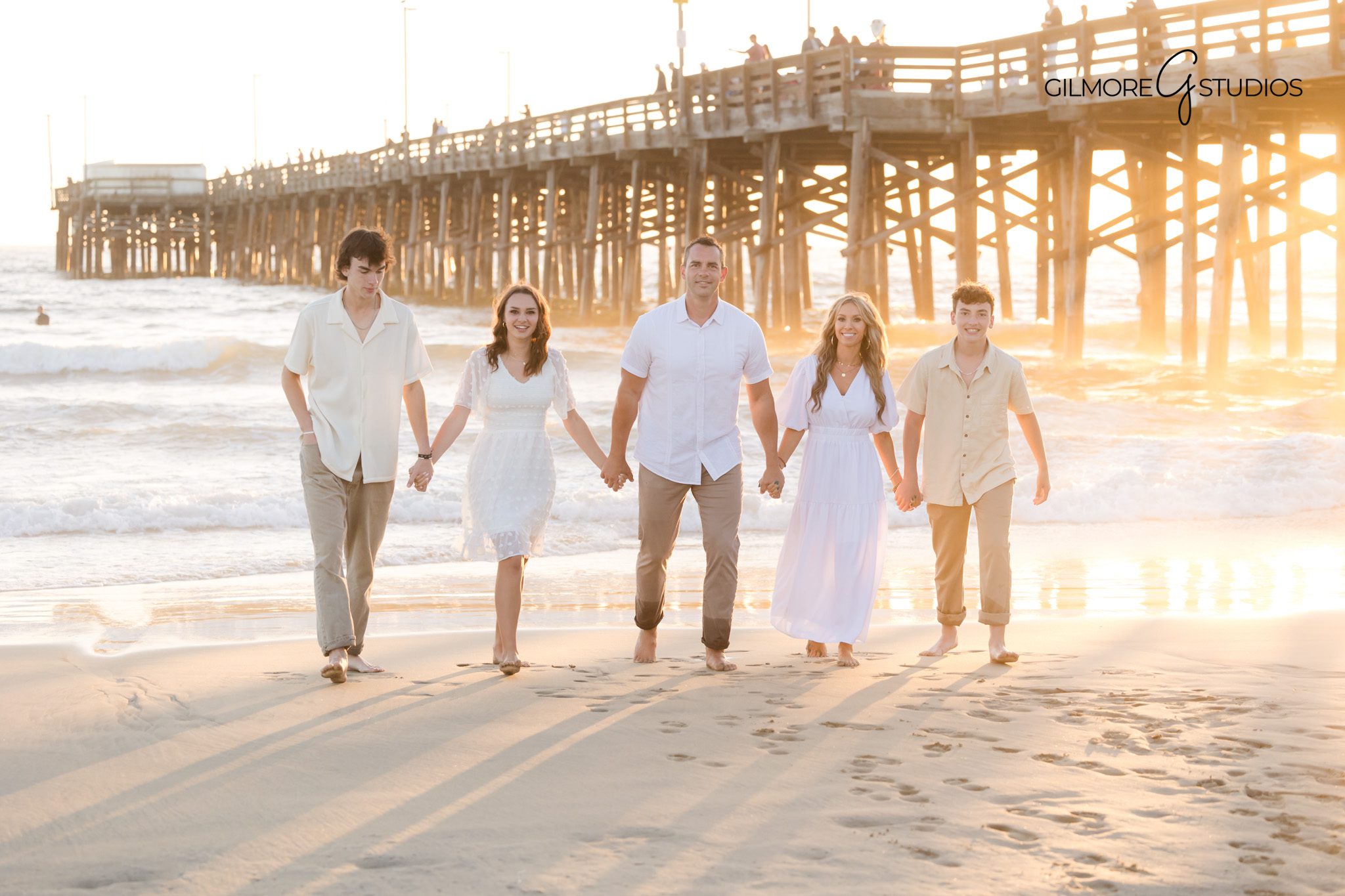 Parents and kids photographed walking at sunset near Newport Beach Pier.
Newport Beach family photographer capturing golden hour photos by the ocean.