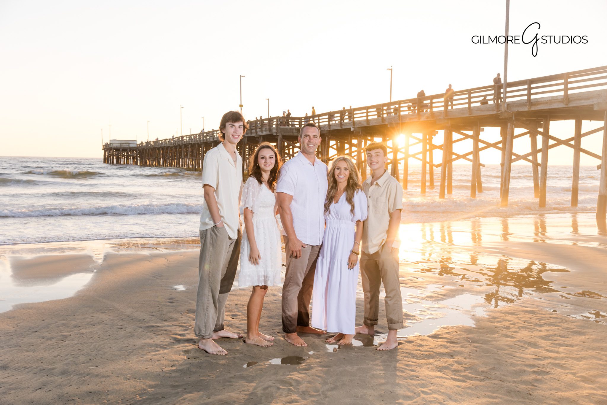 Candid family photography on the sand near Newport Beach Pier.
Sunset family portraits with Newport Beach photographer by the pier.