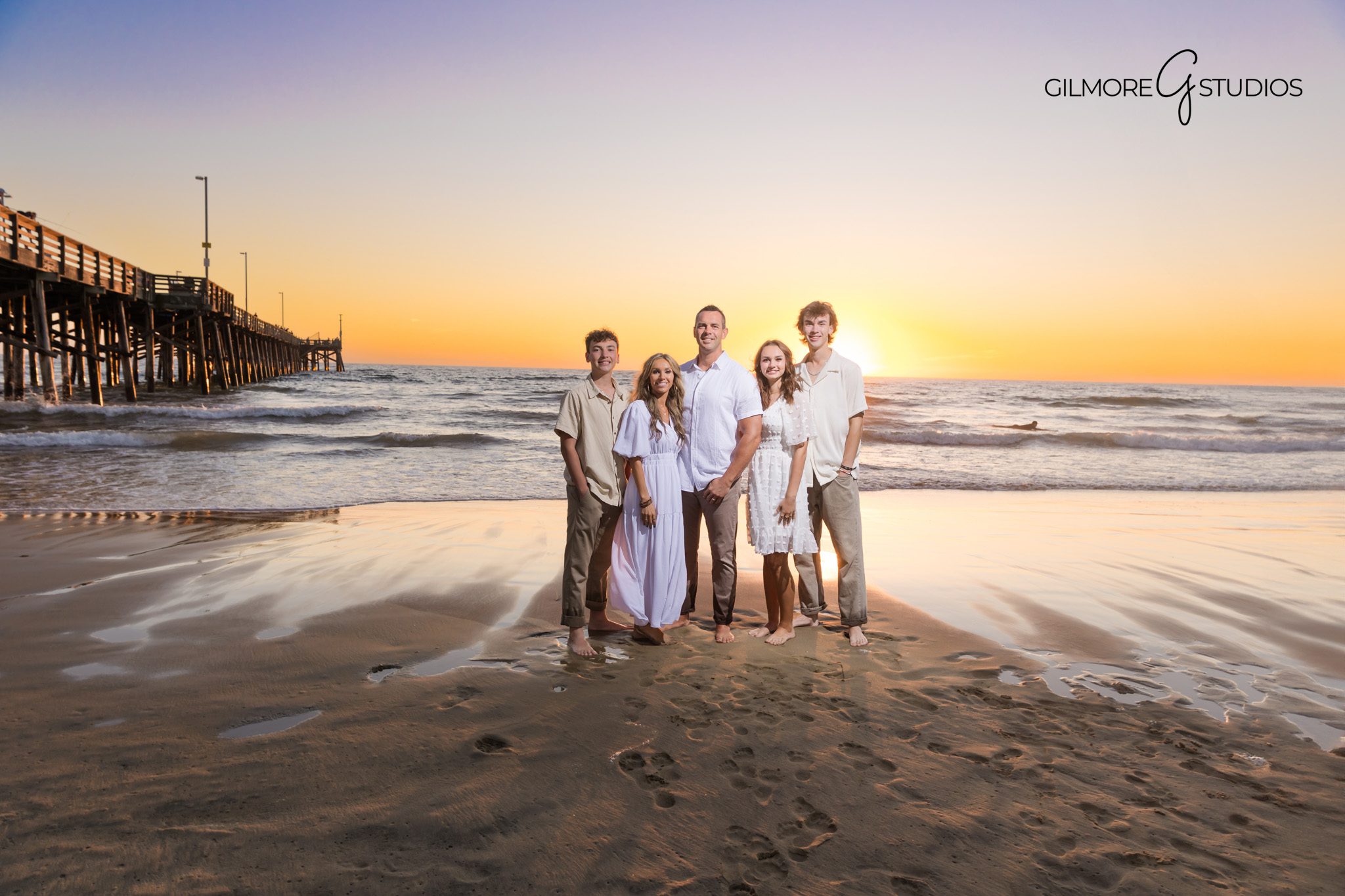Newport Beach Pier family photography at sunset with warm coastal light.
Family portrait photographer capturing sunset session at Newport Beach Pier.