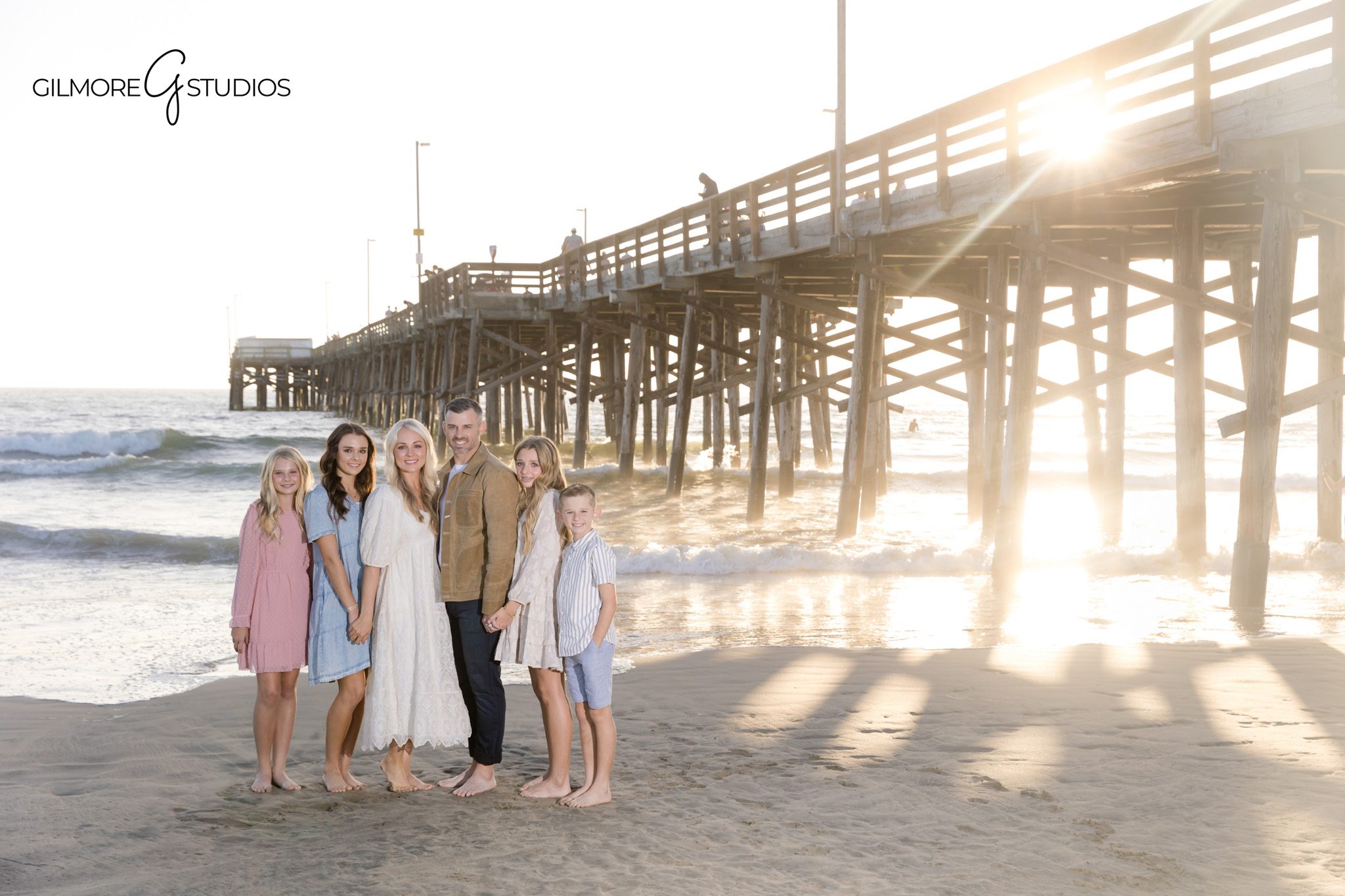 Mini session photographer in Newport Beach capturing beach portrait of siblings

Newport Beach Pier portrait photography of family hugging during minis