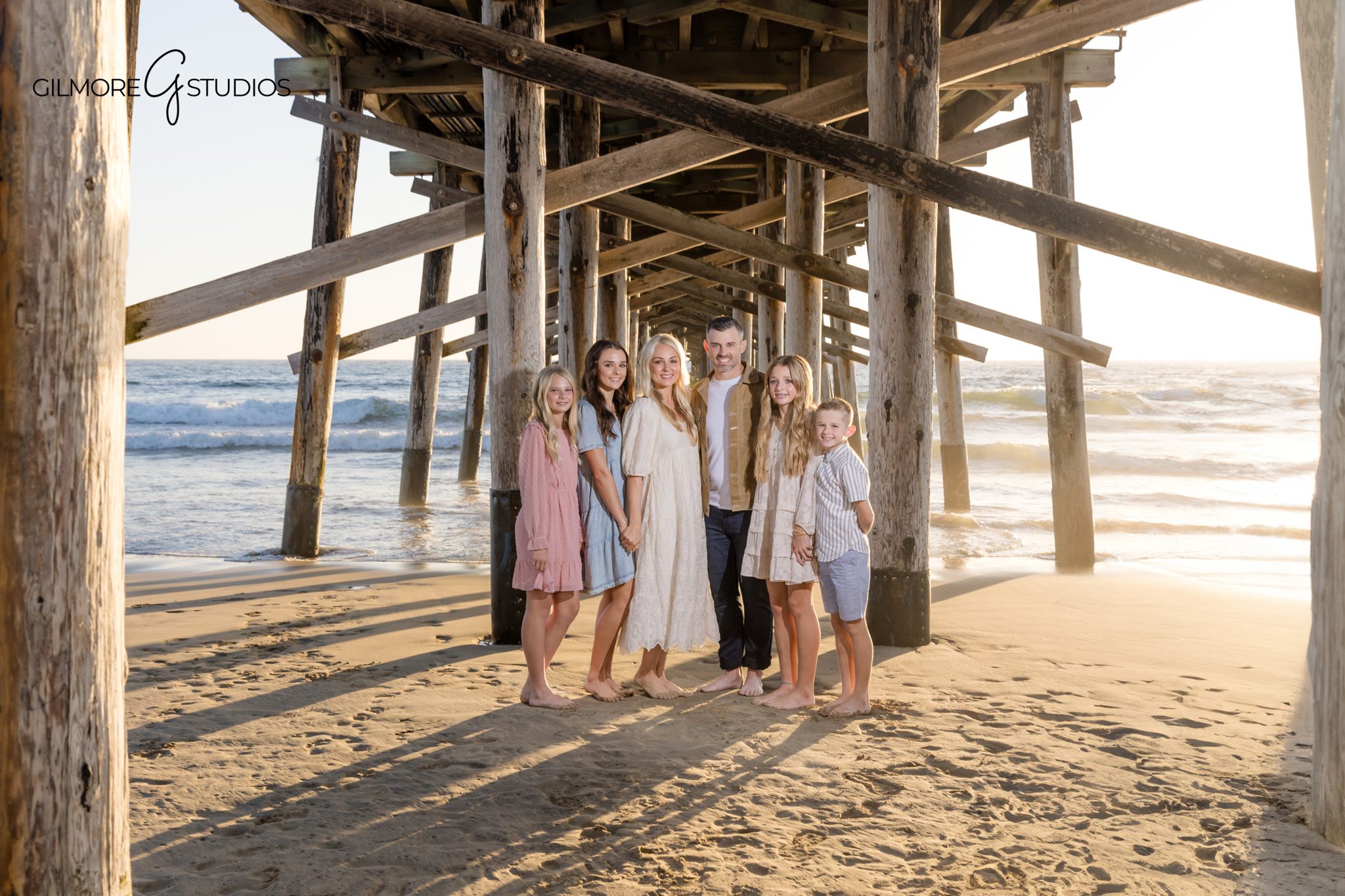 Newport Beach Pier family photography mini session portrait of parents and children standing by the ocean

Newport Beach family photographer capturing candid portrait during pier minis at sunset