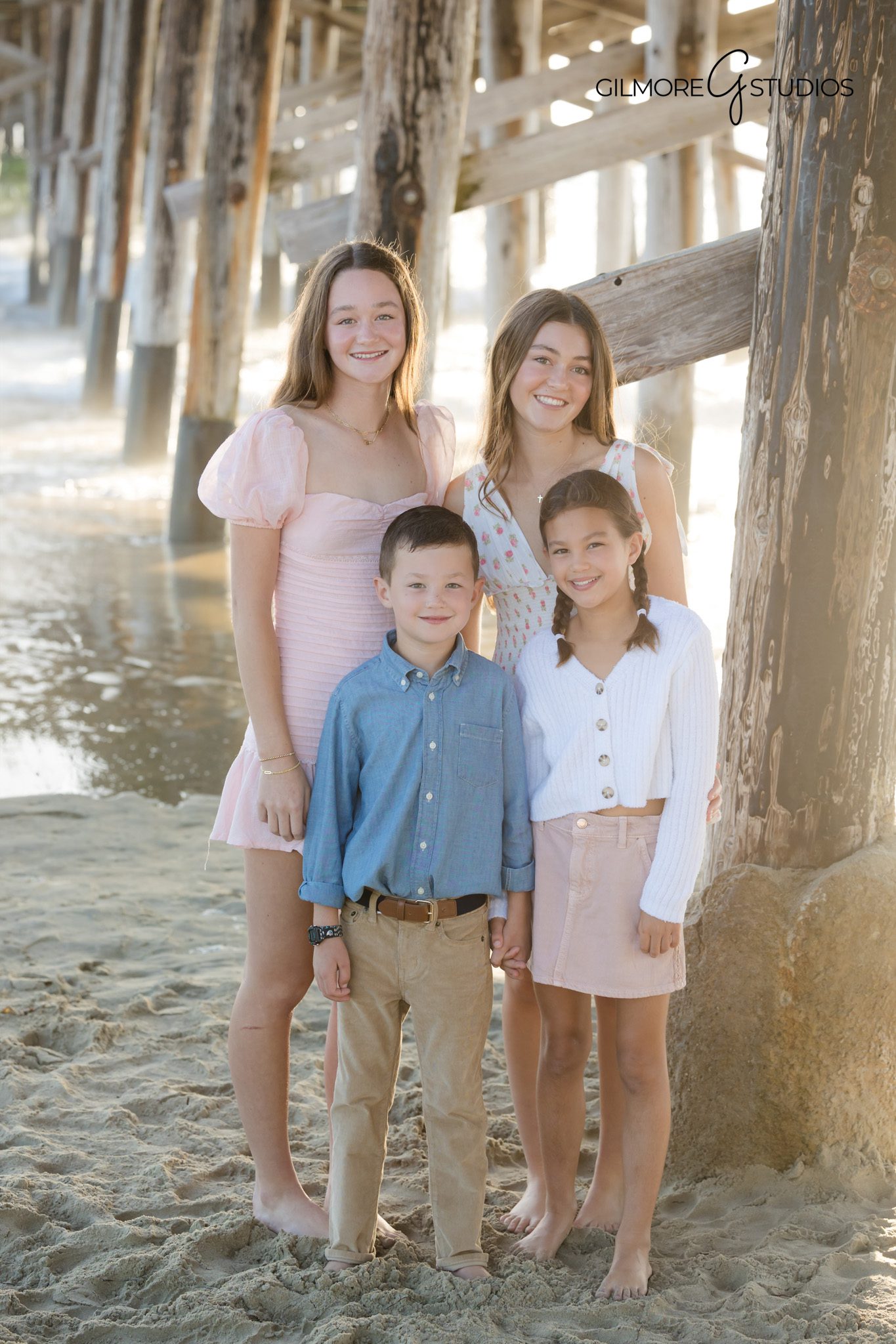 Newport Beach photographer capturing family holding hands along shoreline.

Golden hour family photography at Newport Beach Pier.