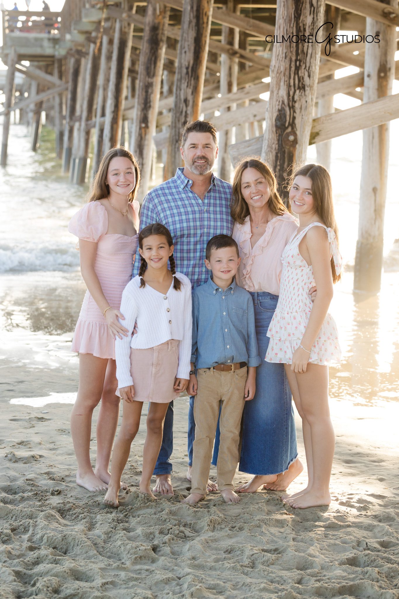 Newport Beach pier family portrait with ocean waves behind the group.

Mini session photographer capturing playful family moment on the sand.