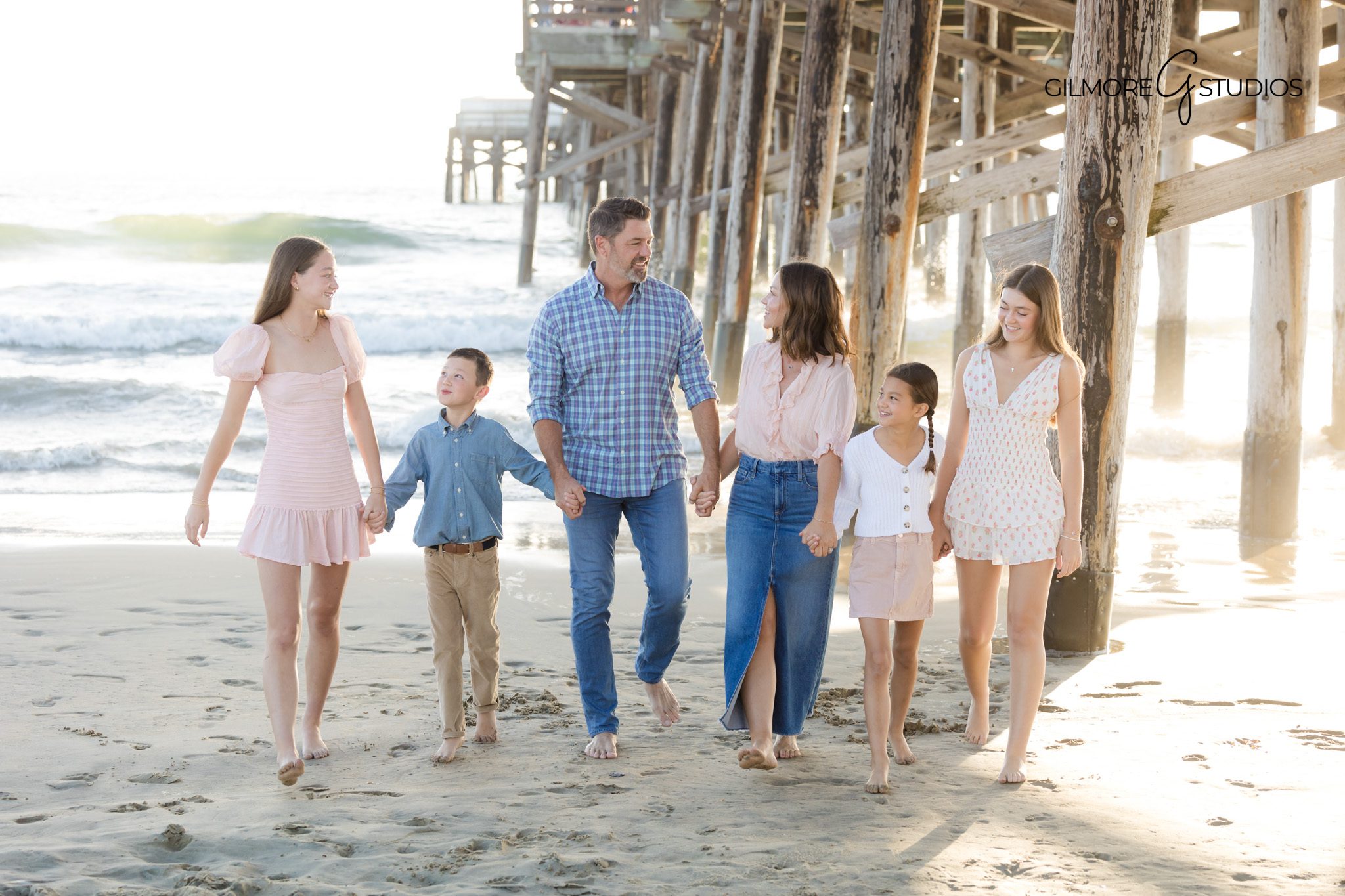 Newport Beach family photography featuring siblings walking near the water.

Portrait photographer capturing relaxed family pose at Newport Beach.