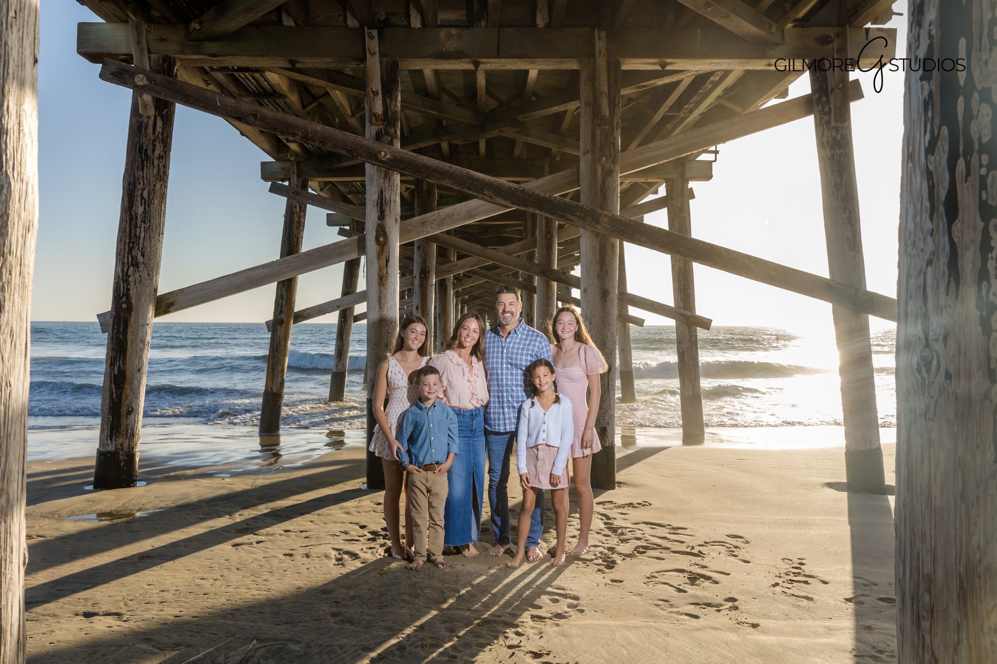Newport Beach photographer capturing family mini session at the pier during sunset.

Family photography at Newport Beach pier with parents walking along the shoreline.