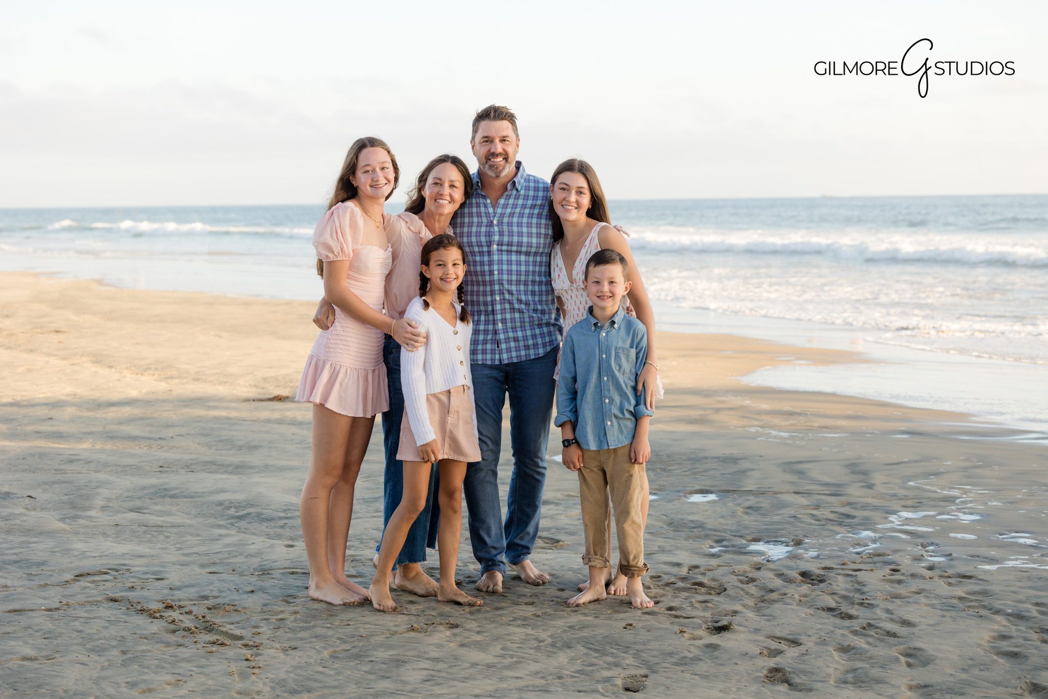 Portrait photography with kids smiling at Newport Pier beach session.

Newport Beach mini session photographer capturing casual family pose.