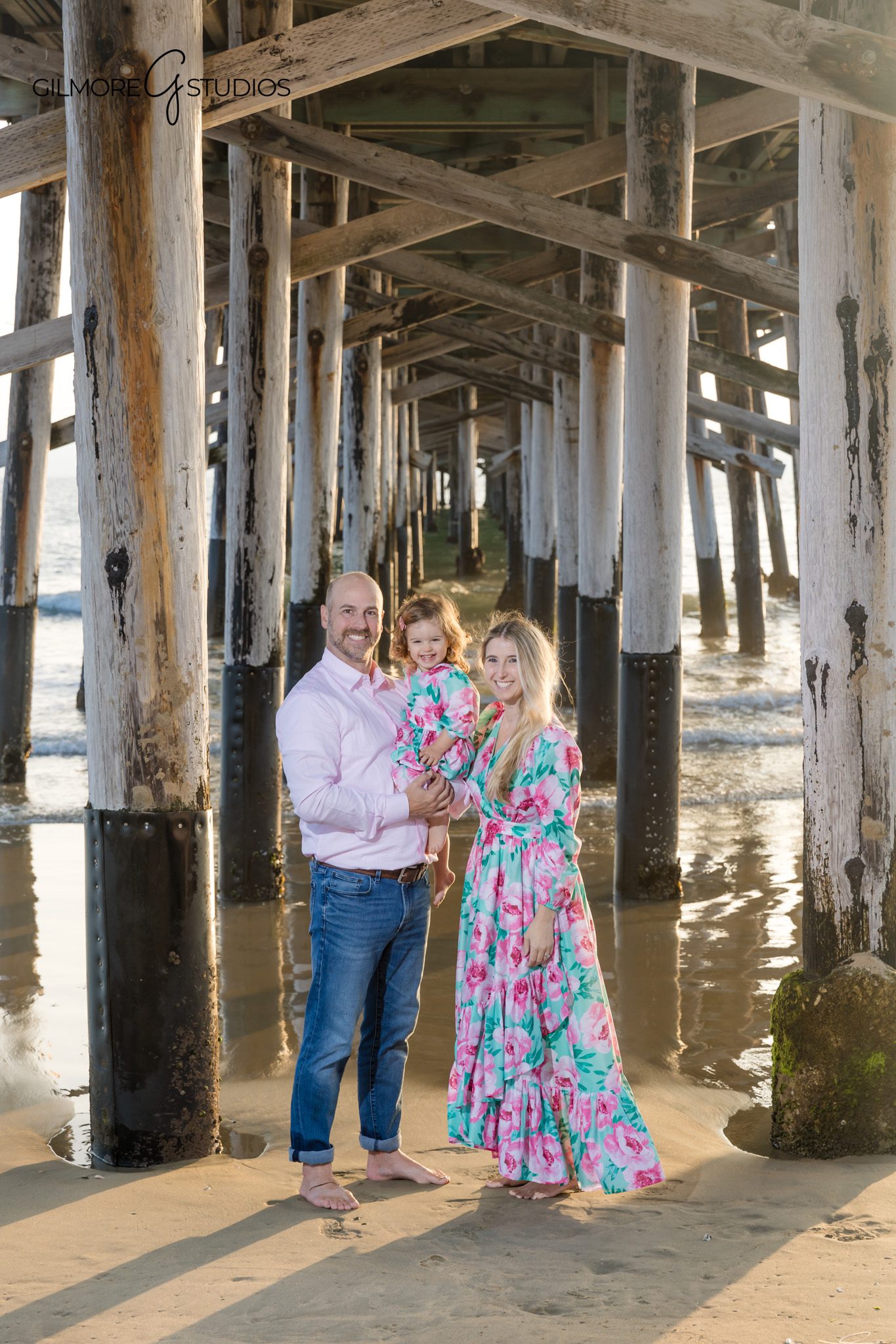 Sunset beach photography with family seated on coastal rocks.

Photographer capturing natural smiles during Newport Pier session.