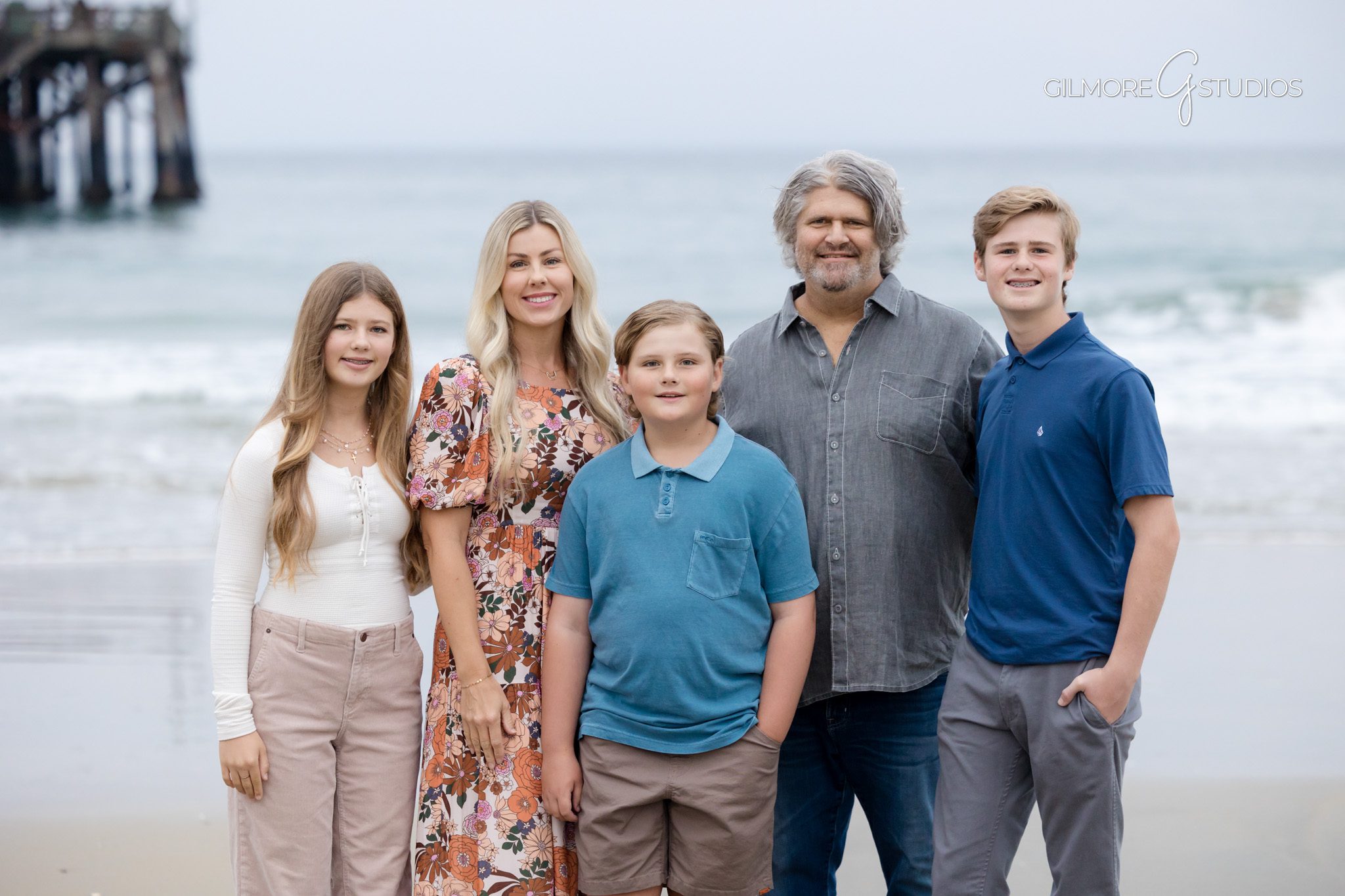 Mini session photography showing family holding hands along shoreline at Newport Beach.

Orange County photographer capturing siblings during Newport Pier mini session.